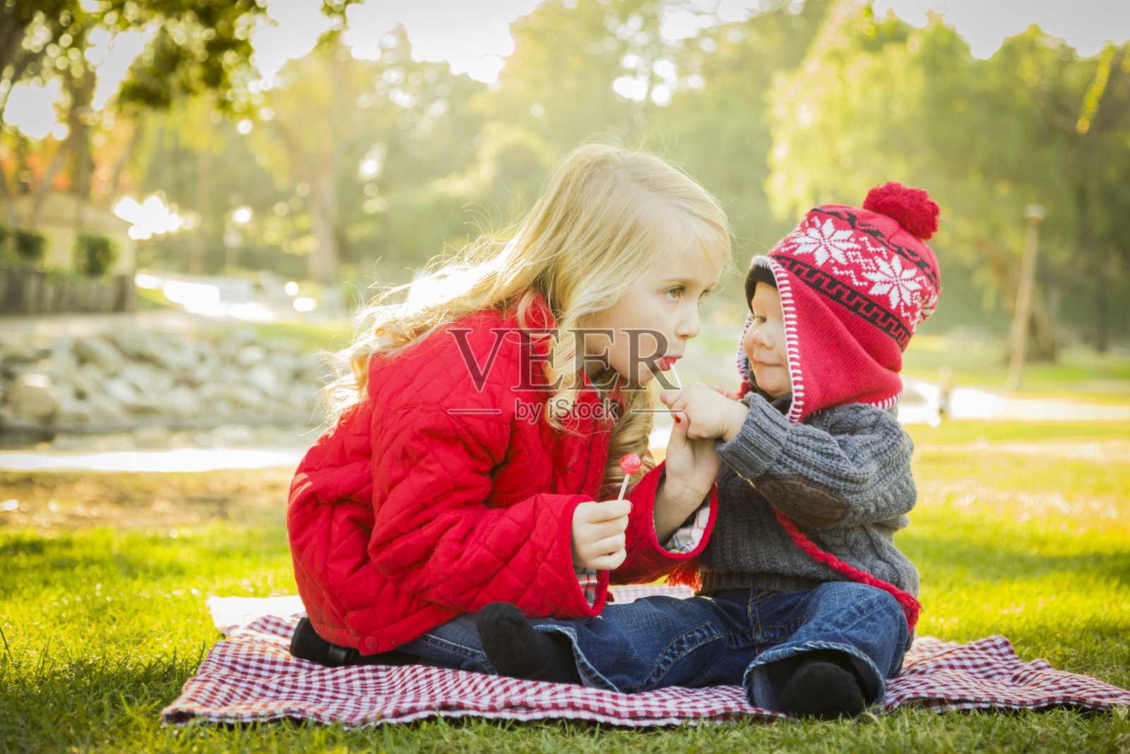 小女孩和弟弟穿着大衣和帽子在户外照片摄影图片