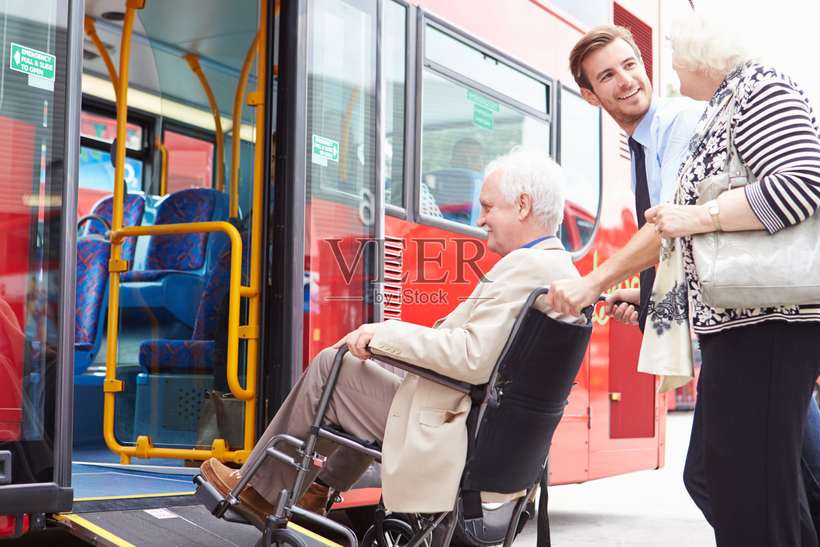 司机帮助老年夫妇通过轮椅坡道登上巴士照片摄影图片