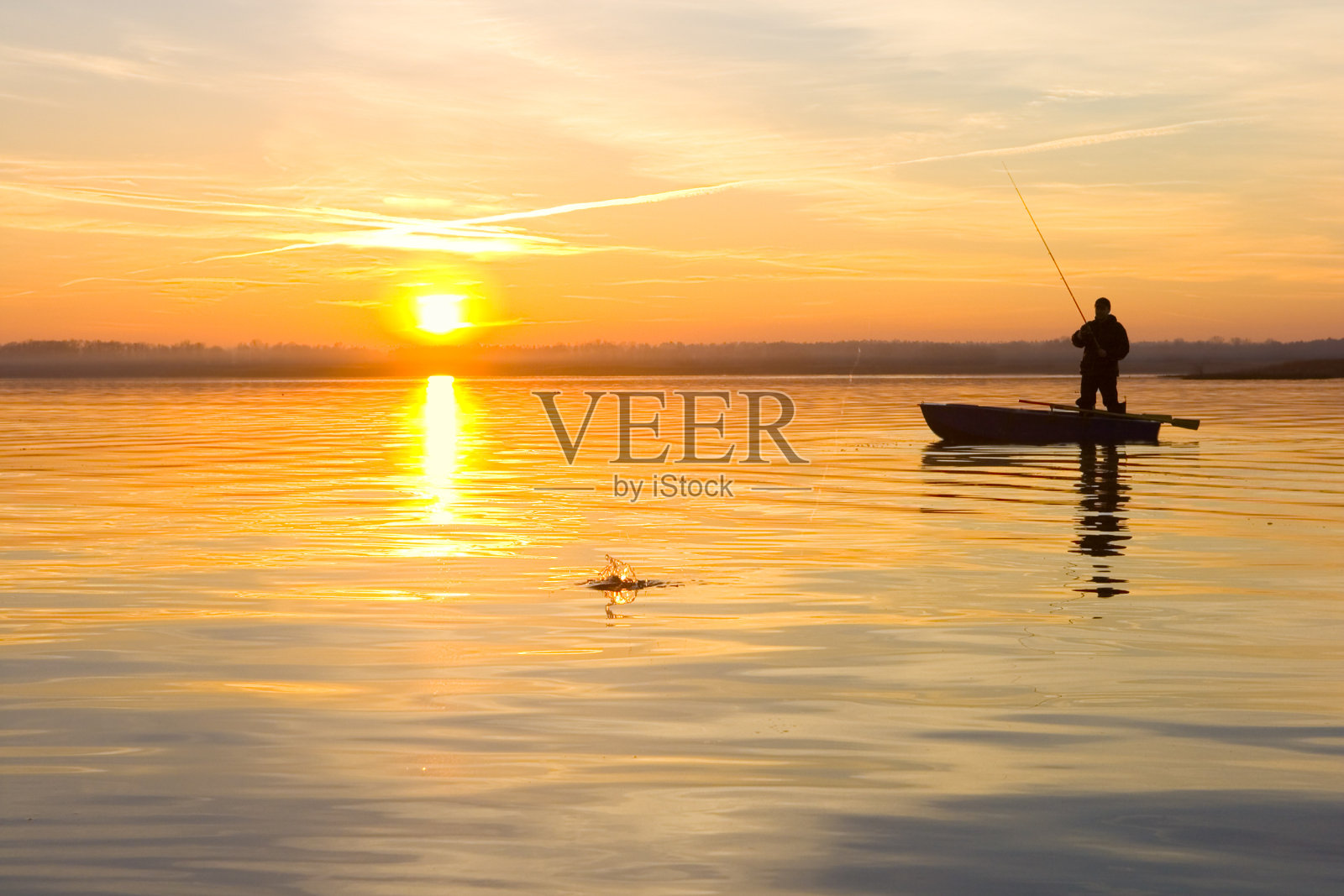 日落时分，渔夫在船上照片摄影图片