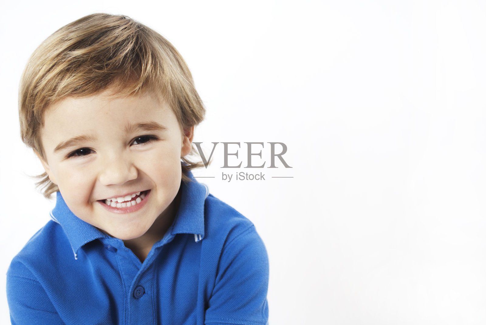 穿着蓝色衬衫的金发小男孩微笑着照片摄影图片