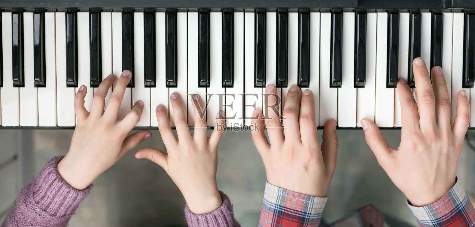 钢琴键盘俯视图和手的孩子和母亲照片摄影图片