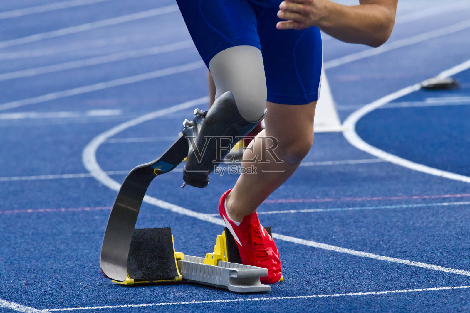 残疾短跑运动员在蓝色跑道上照片摄影图片