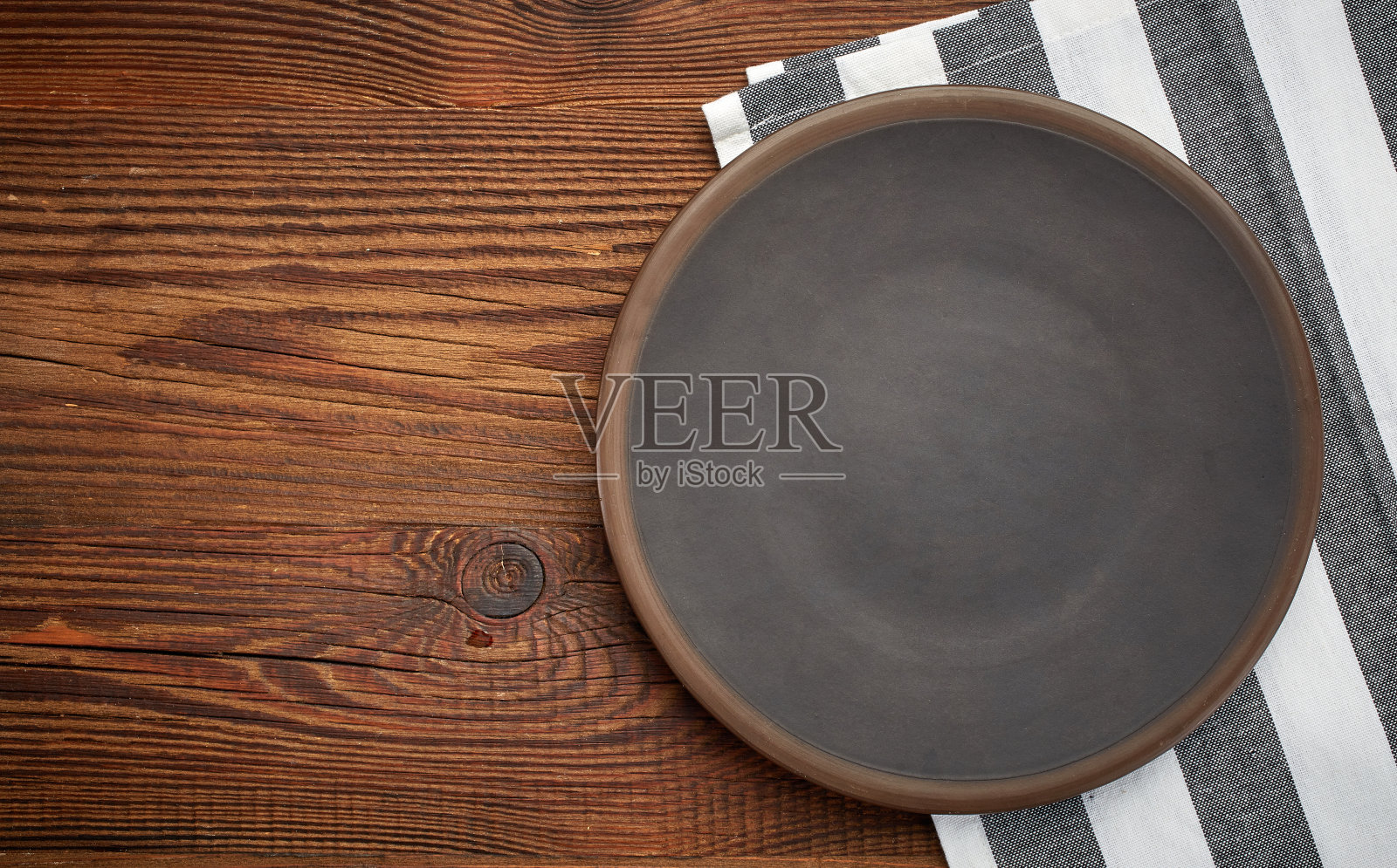 餐巾和深色的盘子放在木桌上照片摄影图片