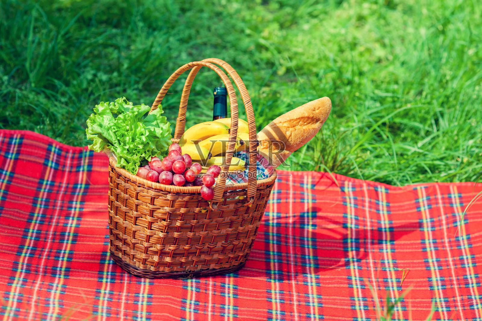 毯子上有水果的野餐篮子照片摄影图片
