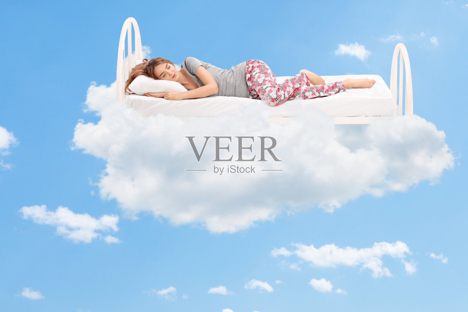 在云里的一张舒适的床上睡觉的女人照片摄影图片