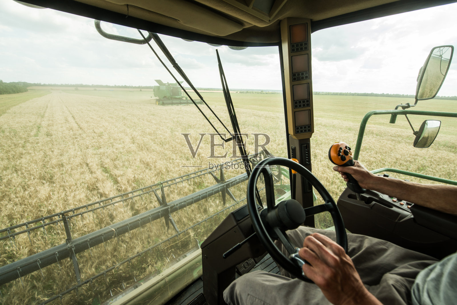 农民在麦田сombine收割机的方向盘上照片摄影图片