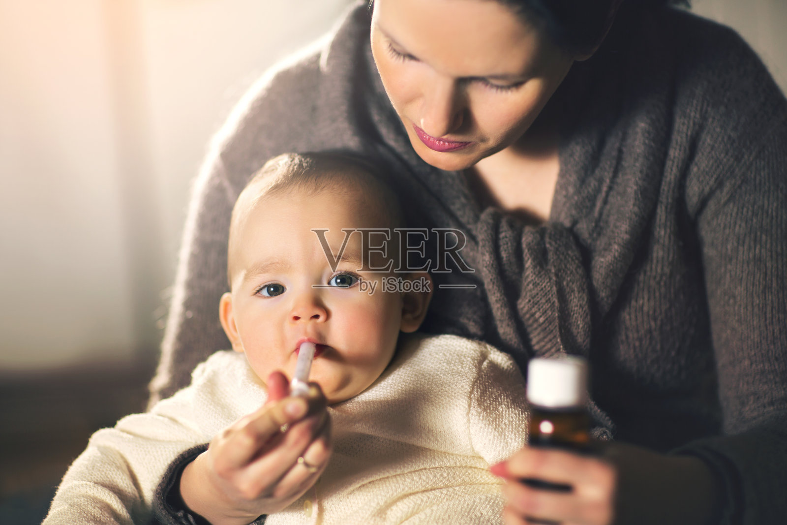 母亲在家给婴儿吃药照片摄影图片