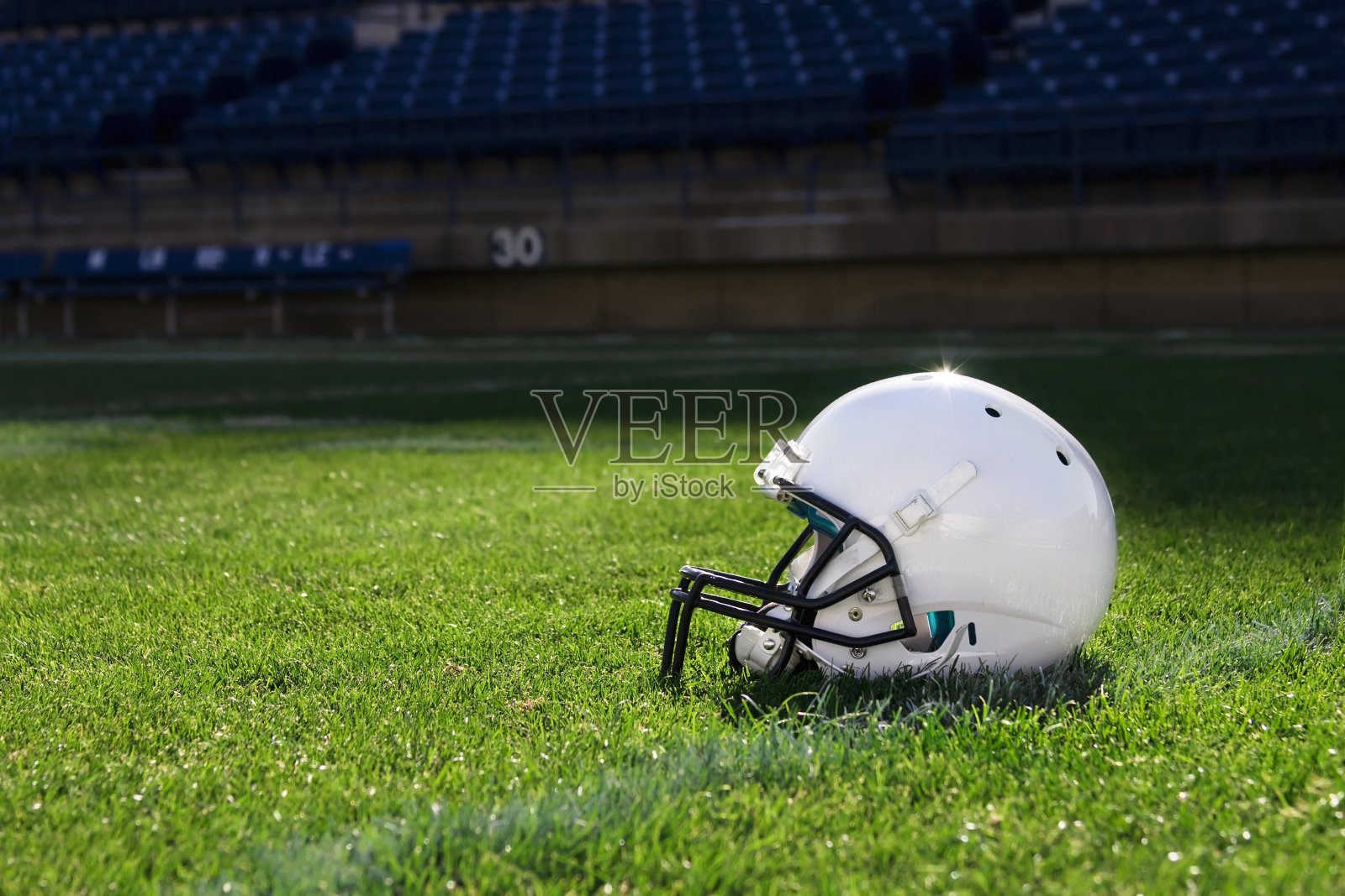 赛场上的一顶白色橄榄球头盔照片摄影图片
