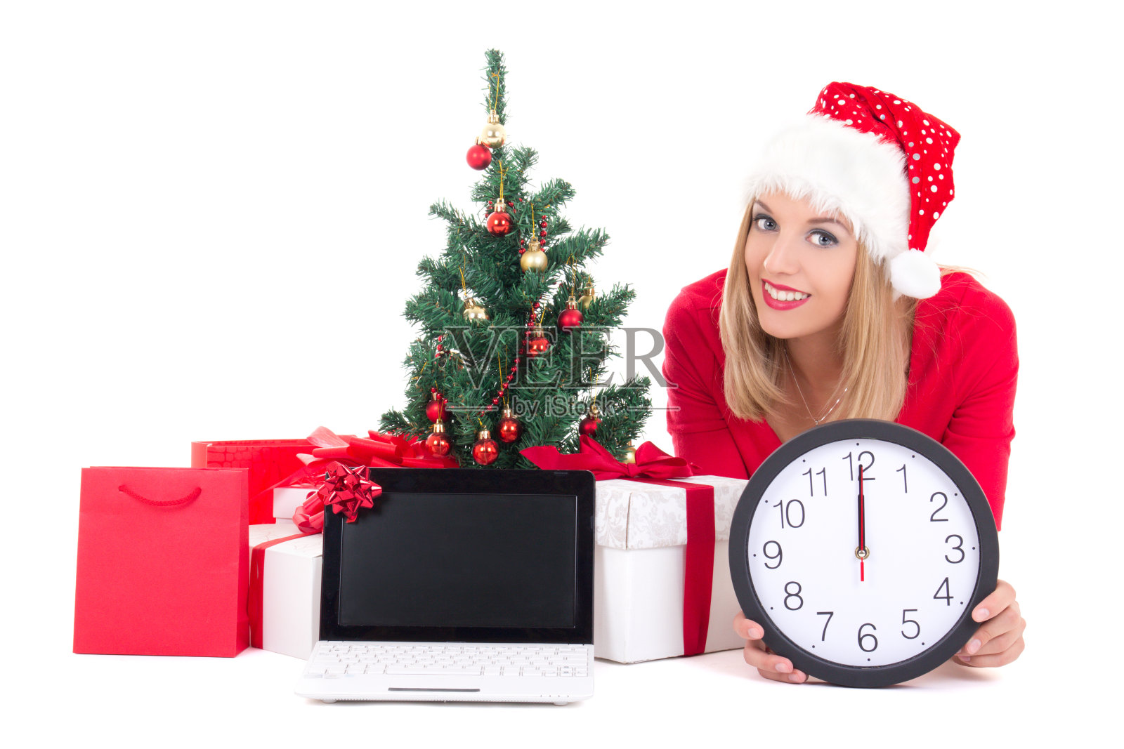 女人躺着，拿着时钟、笔记本、圣诞树和礼物照片摄影图片