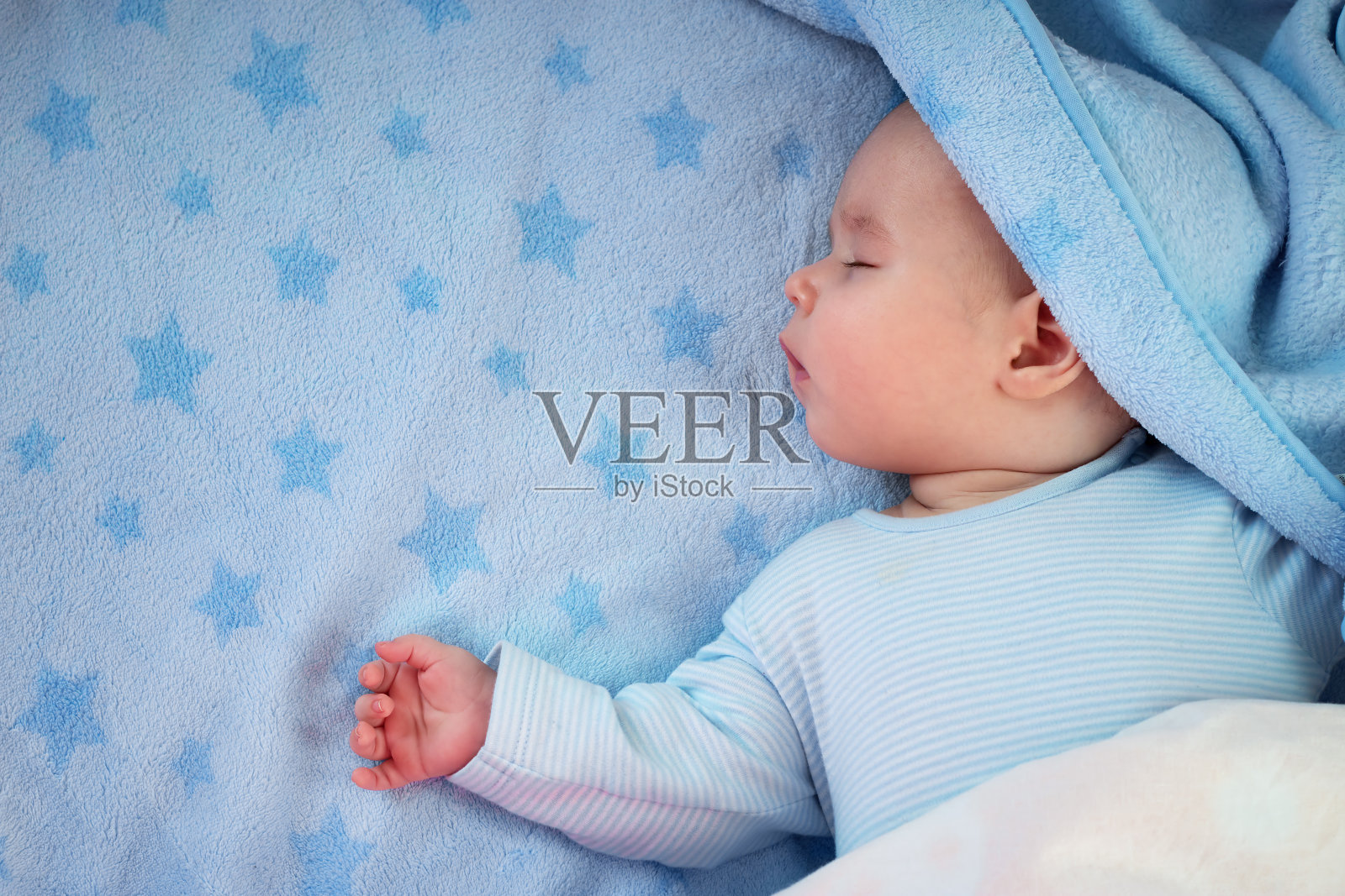 三个月大的婴儿睡在蓝色的毯子上照片摄影图片