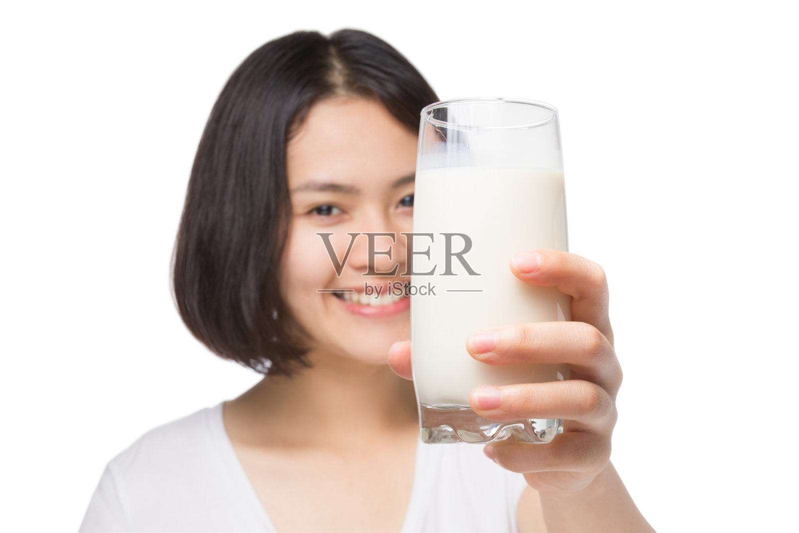 可爱健康的女人展示一杯牛奶(注意玻璃)。照片摄影图片