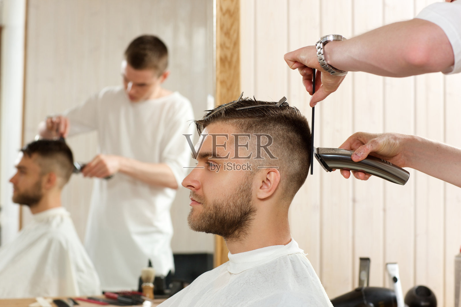 理发师用理发器给他的客户理发照片摄影图片