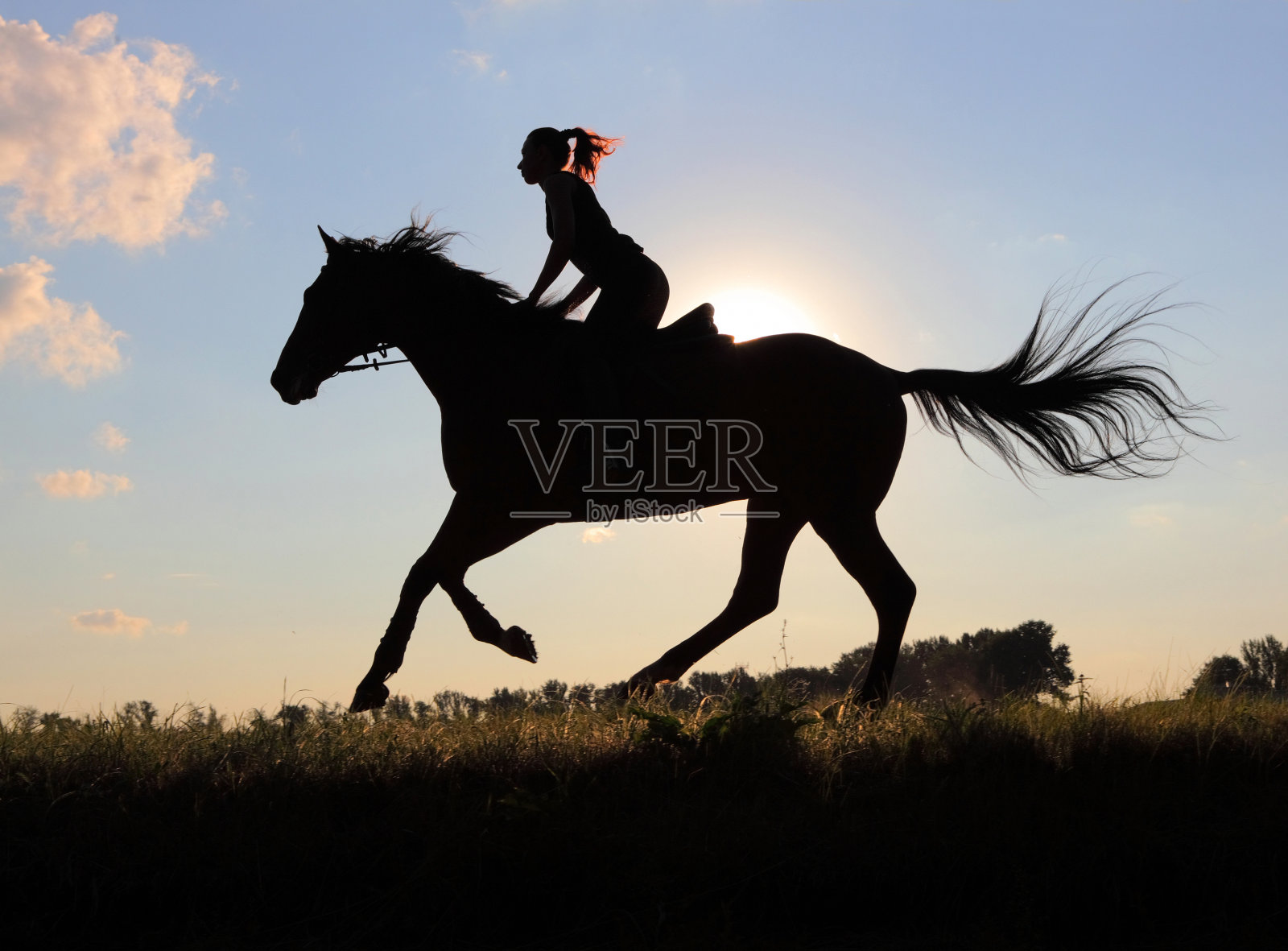 一个乡村女孩在日落时分骑马照片摄影图片