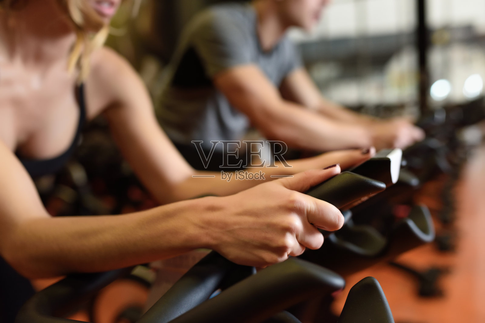 两人在健身房骑自行车，锻炼双腿做有氧运动骑自行车。照片摄影图片
