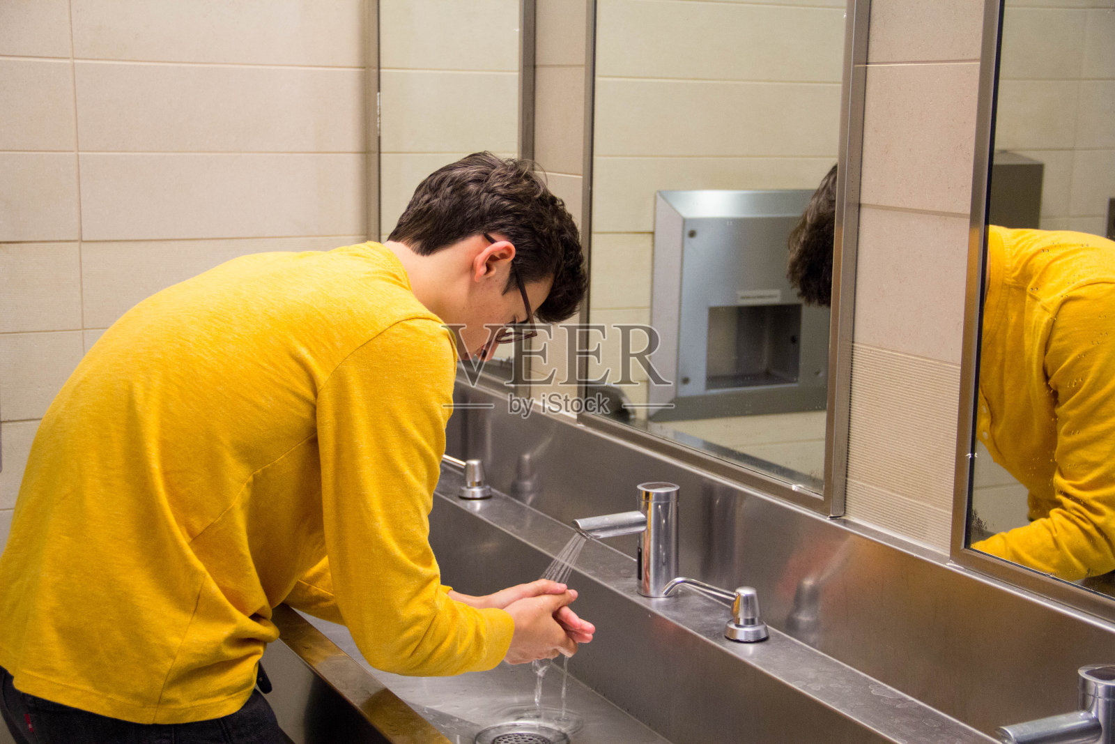 青少年在公共厕所洗手照片摄影图片