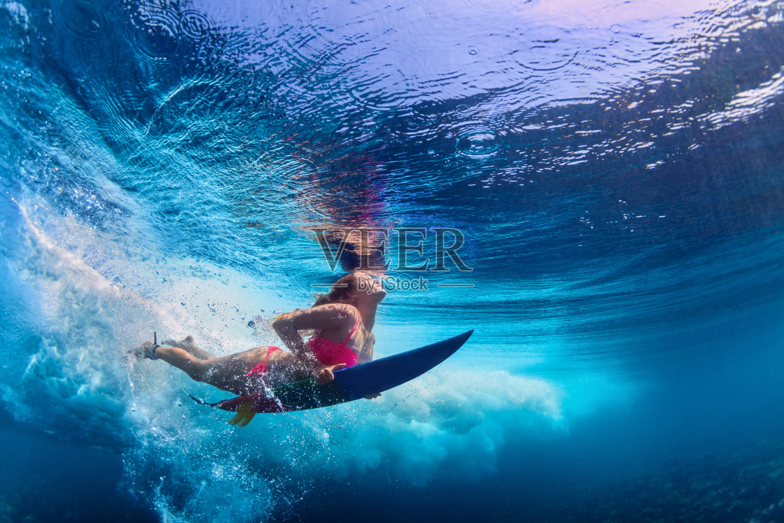 美丽的冲浪者女孩潜水与冲浪板照片摄影图片