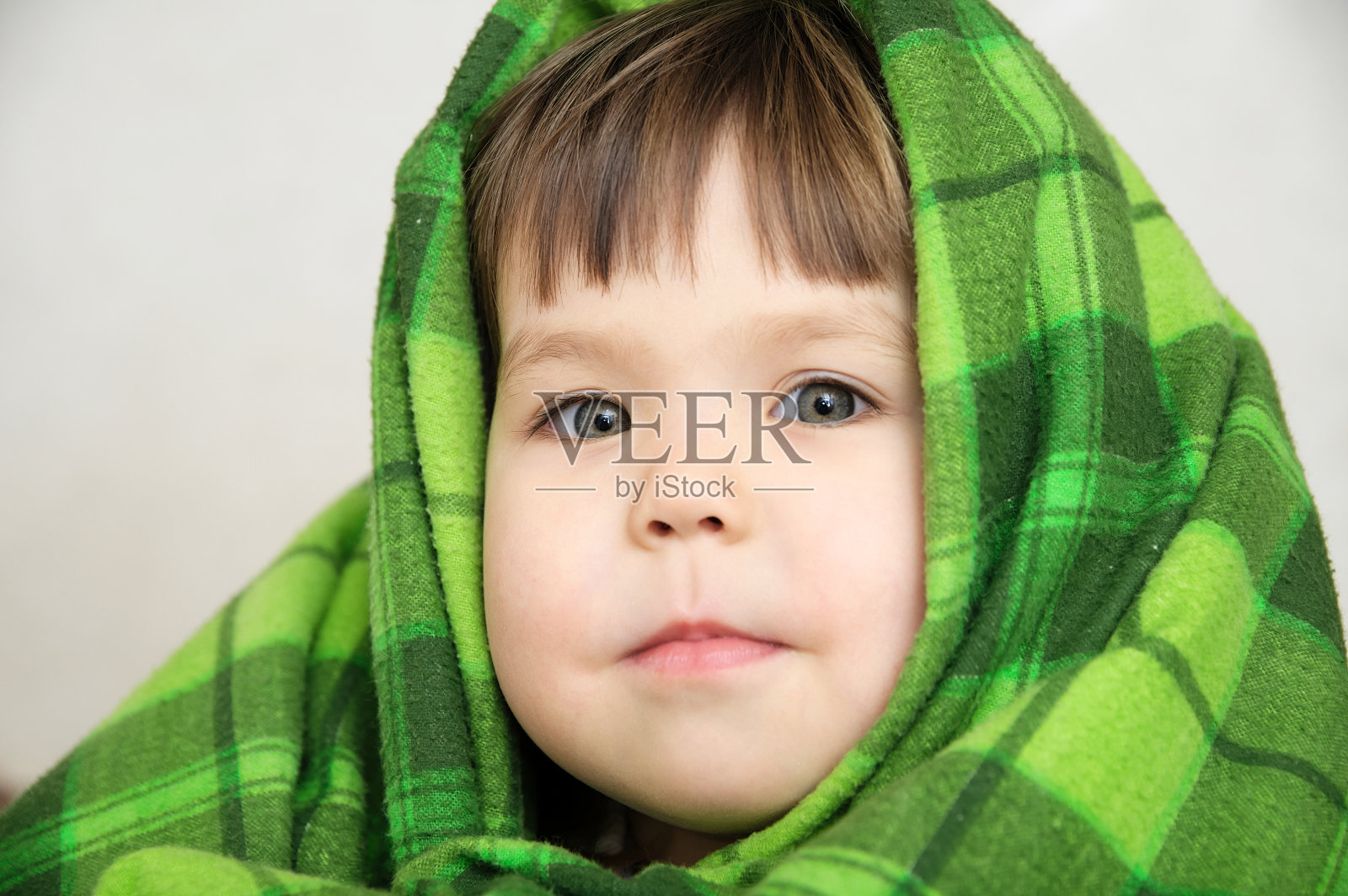 孩子肖像在毯子微笑表达情感，温暖的毯子舒适照片摄影图片