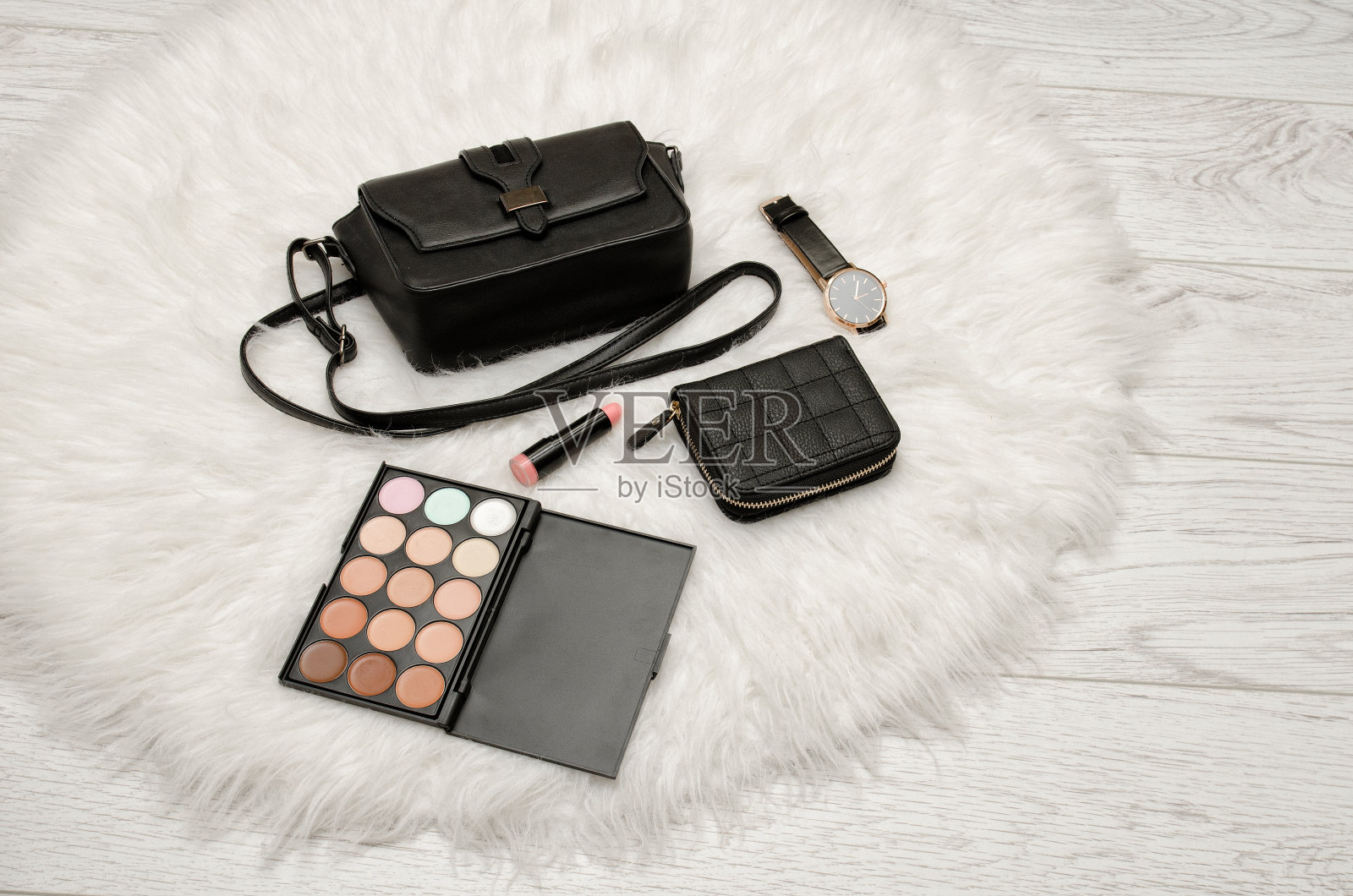 眼影，钱包，口红，手表和黑色手袋上的白色皮草。时尚的概念照片摄影图片