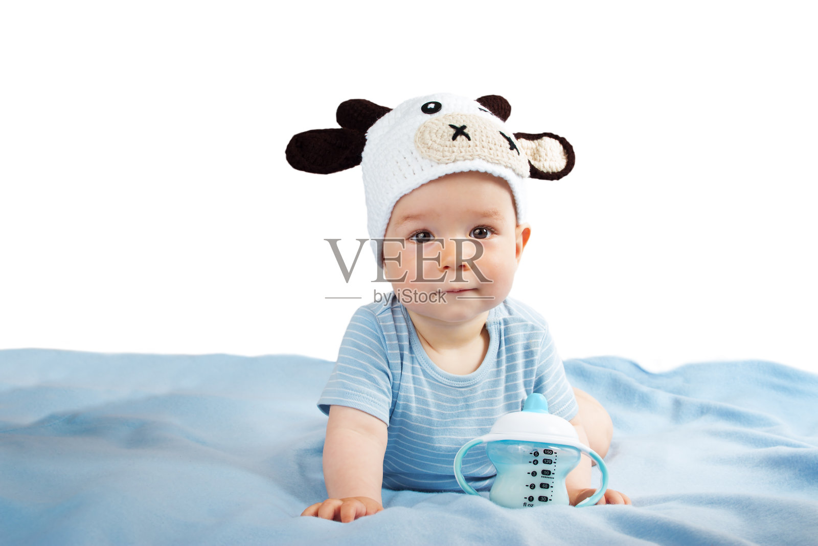 婴儿戴着牛帽喝牛奶照片摄影图片