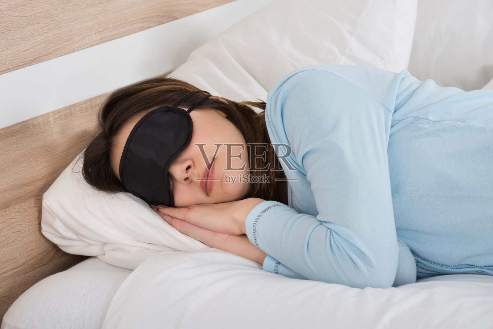 床上戴着眼罩睡觉的女人照片摄影图片