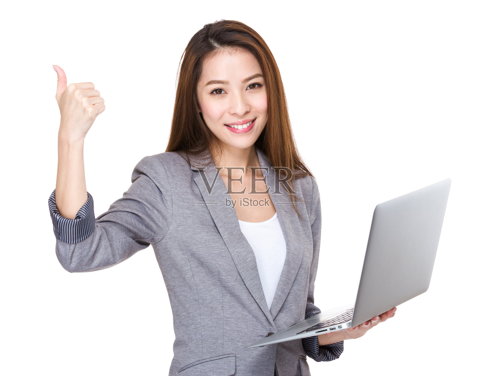 拿着笔记本电脑，竖起大拇指的女商人照片摄影图片