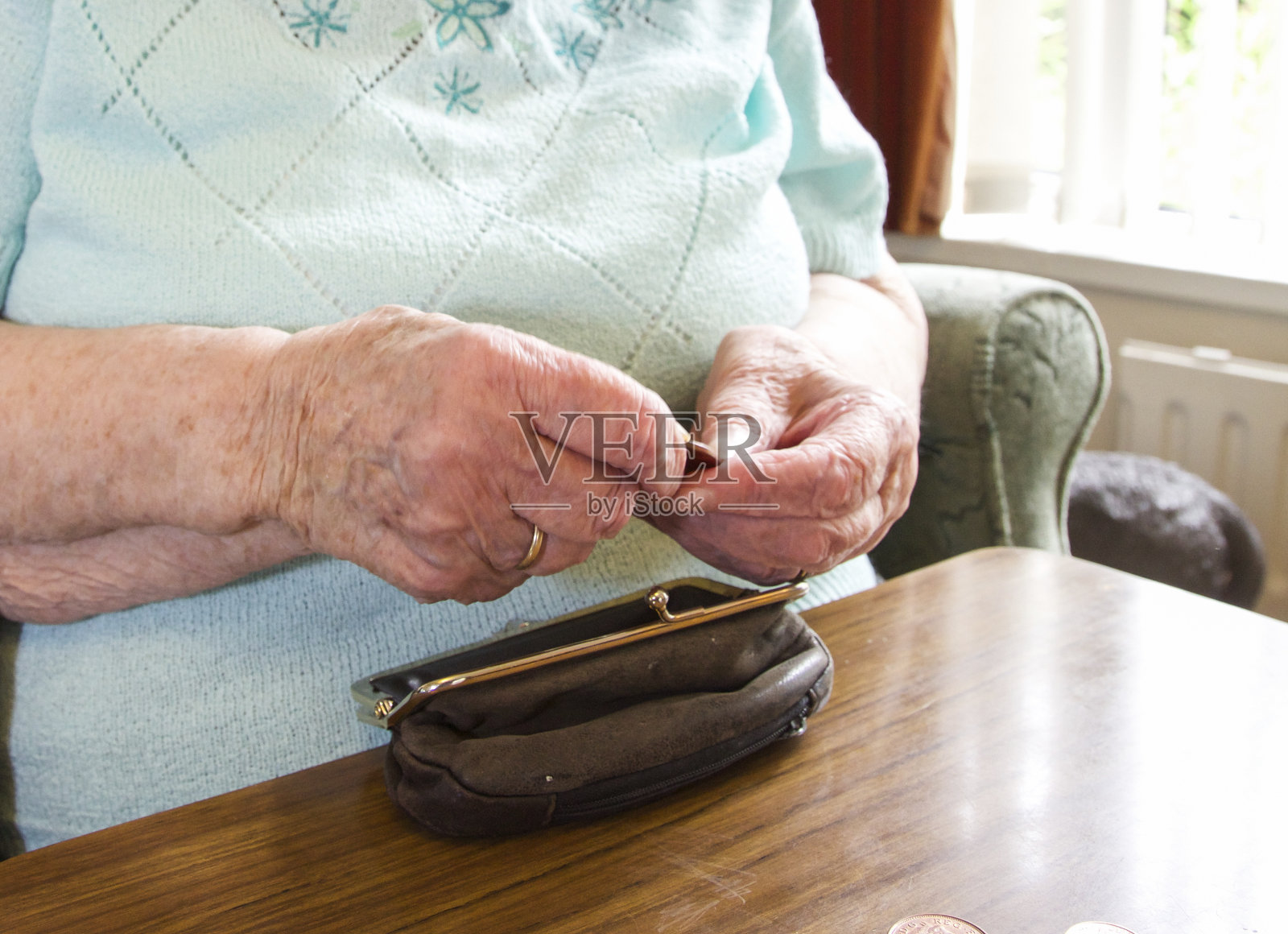 一位老妇人在检查钱包里的现金照片摄影图片