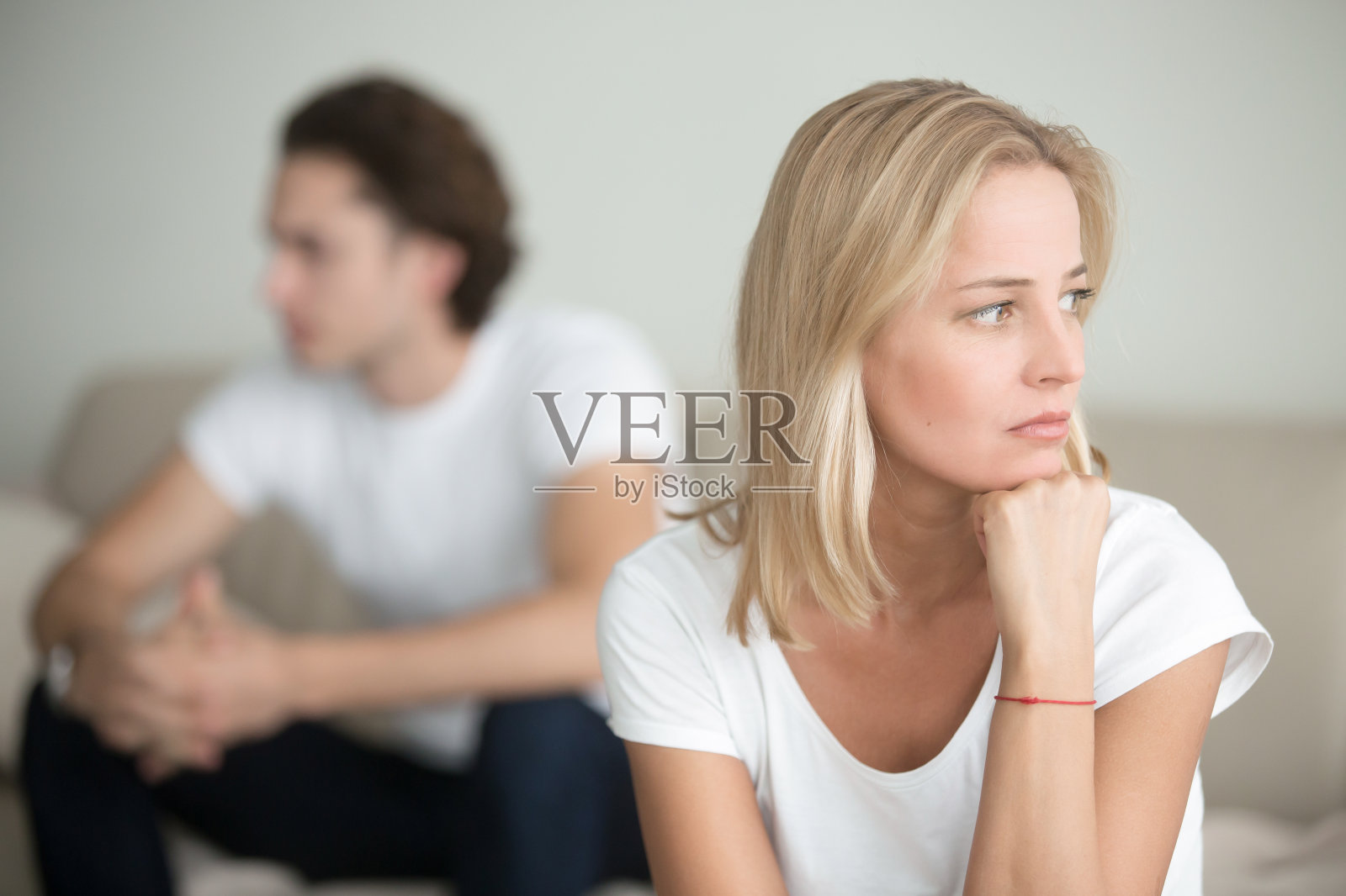 伤心的女人在思考一个问题，男人坐在一旁照片摄影图片