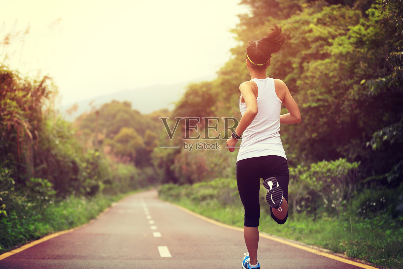 年轻的健身女性跑步在森林小径照片摄影图片