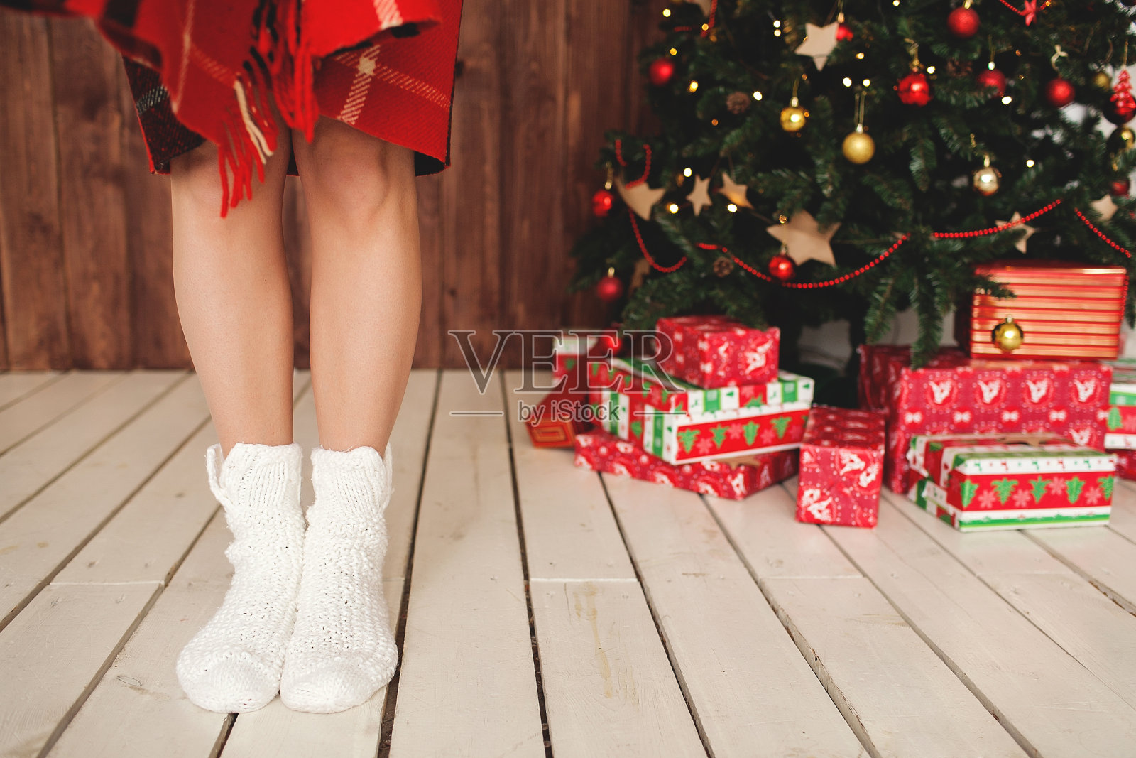 女人穿着袜子站在装饰好的圣诞树前照片摄影图片
