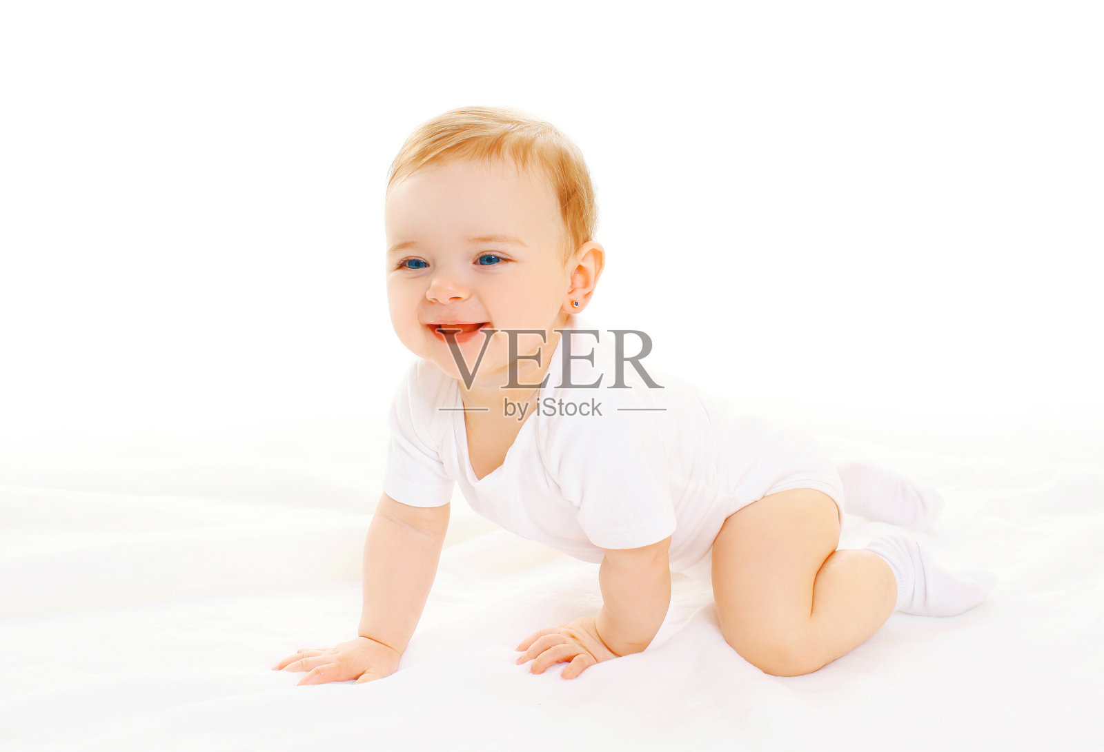 快乐微笑的婴儿在白色的背景上爬行照片摄影图片