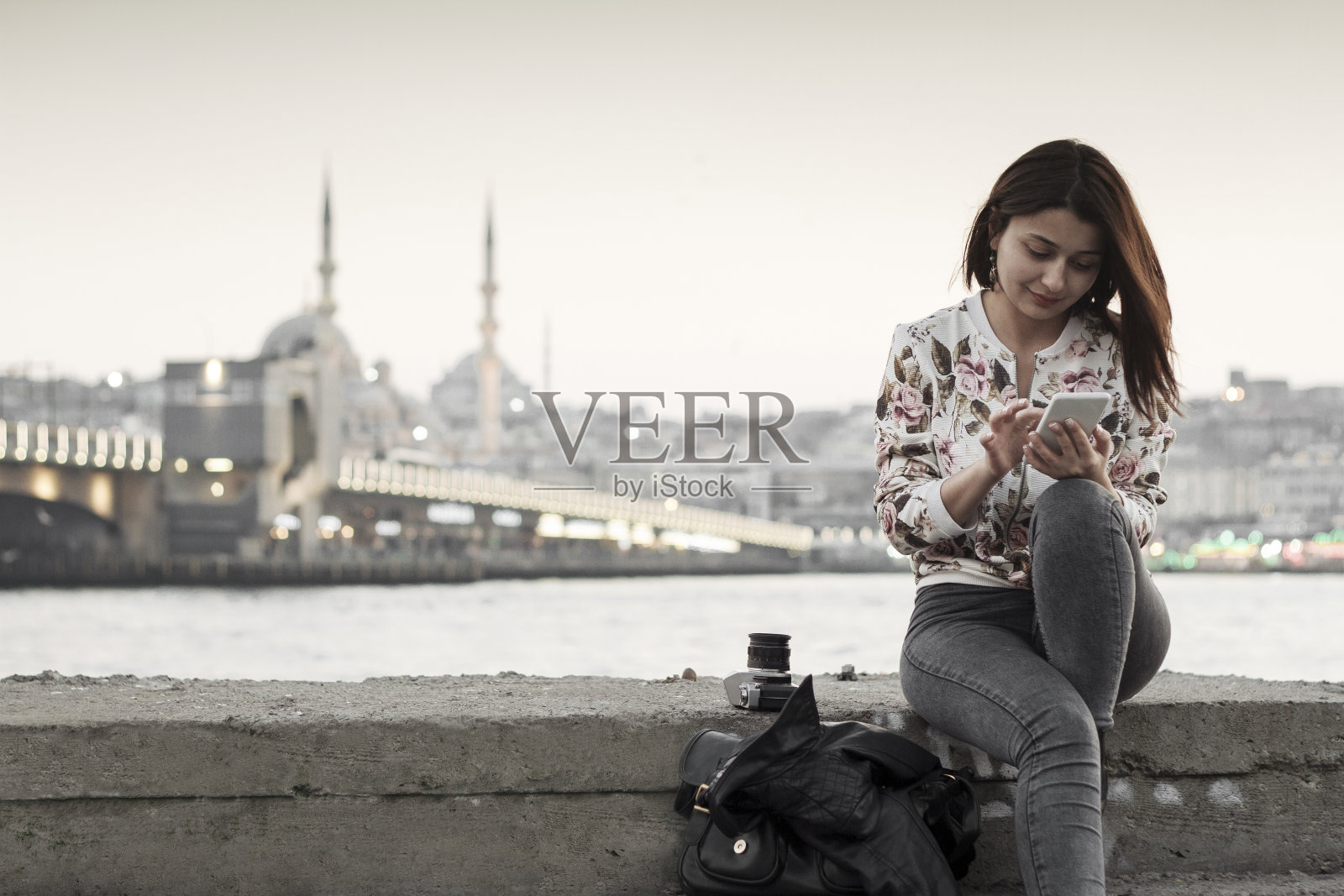 土耳其伊斯坦布尔的漂亮女人在用智能手机照片摄影图片