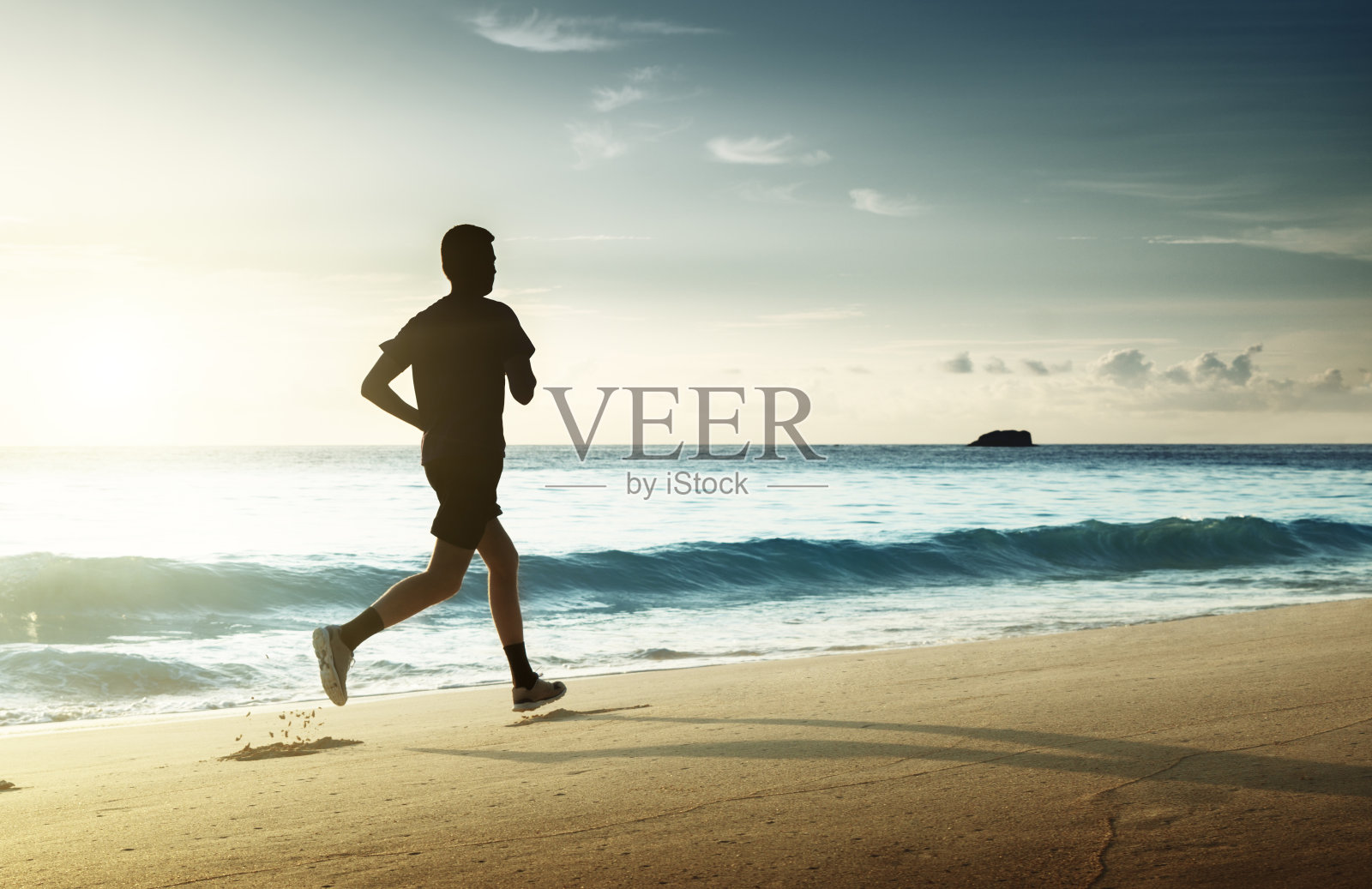 日落时分，在热带海滩上跑步的人照片摄影图片