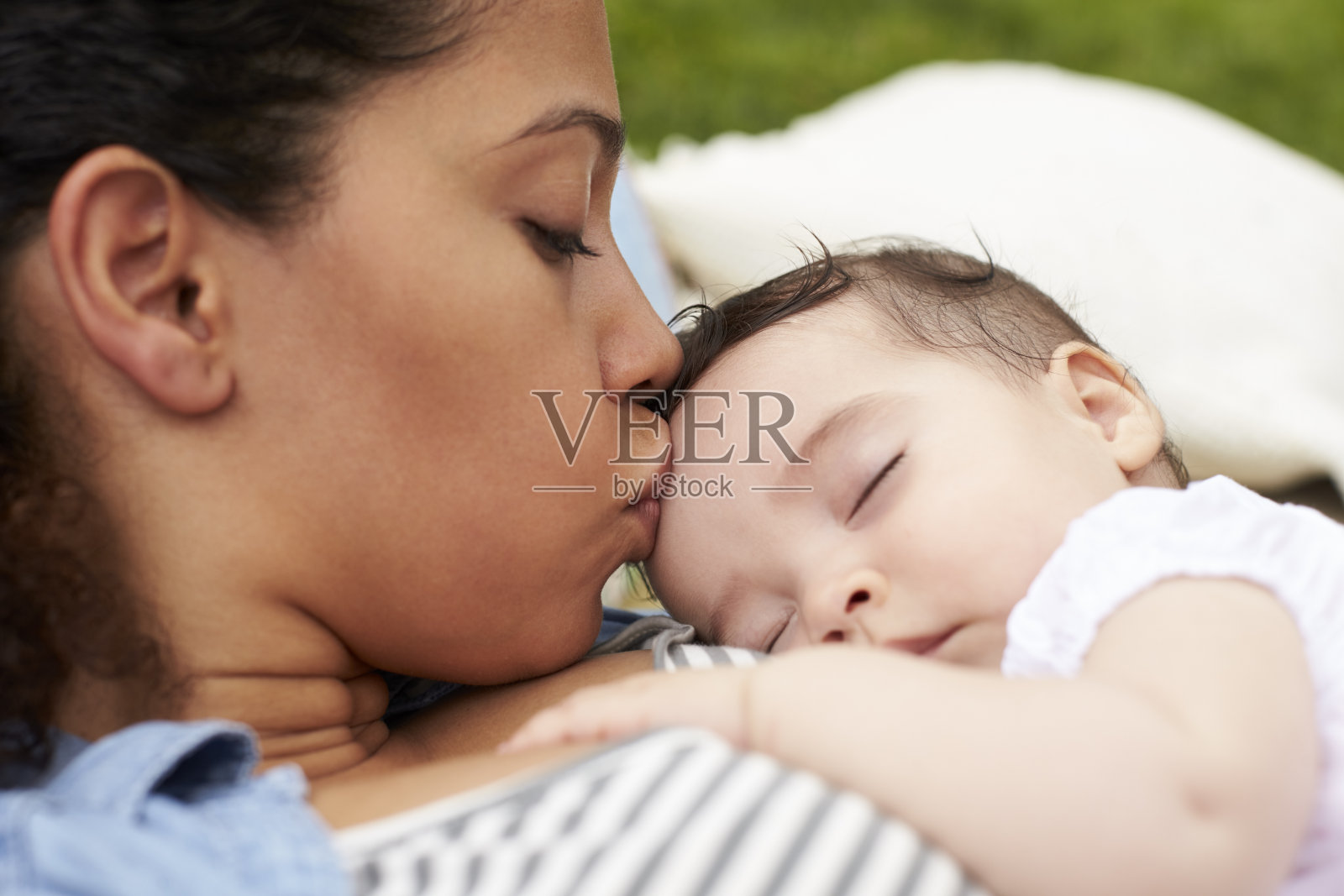母亲与婴儿在花园里的地毯上放松的特写照片摄影图片