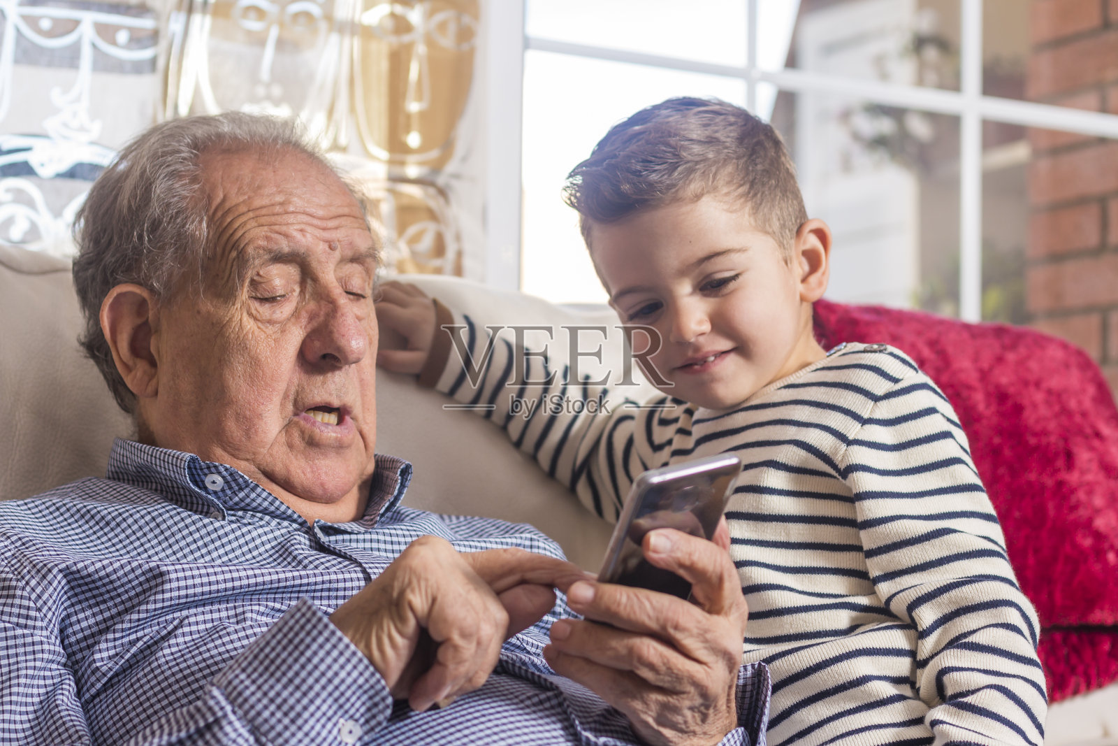 爷爷和孙子在看智能手机照片摄影图片