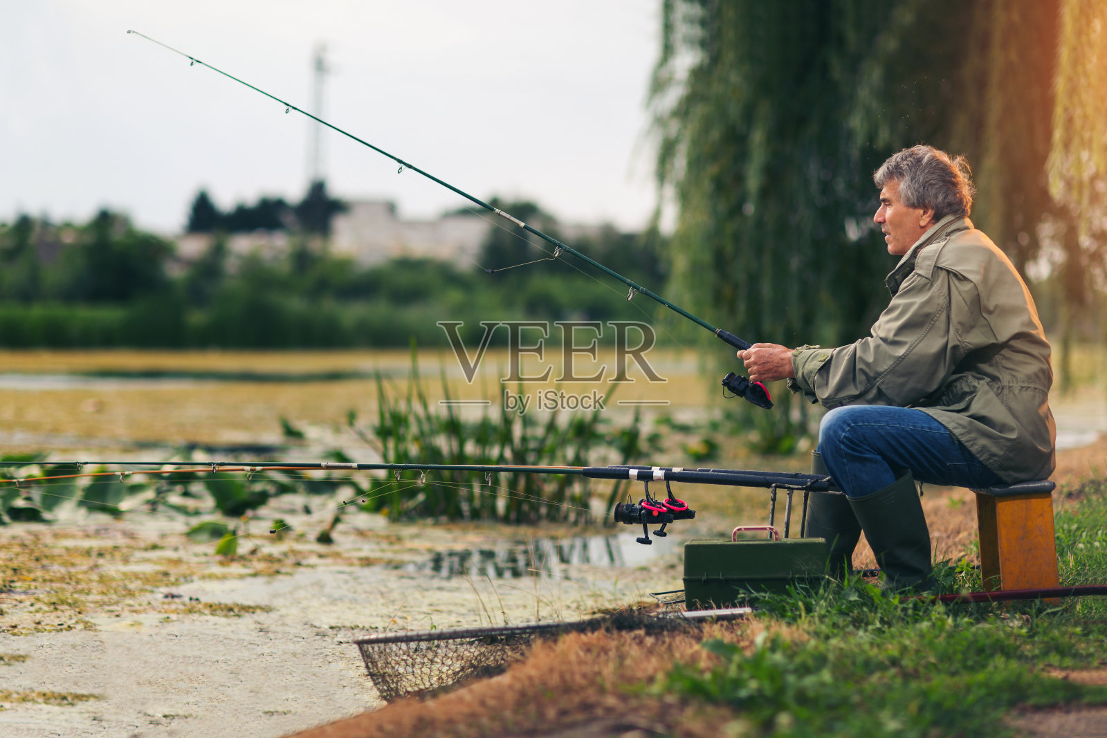一位老人在淡水湖上钓鱼照片摄影图片