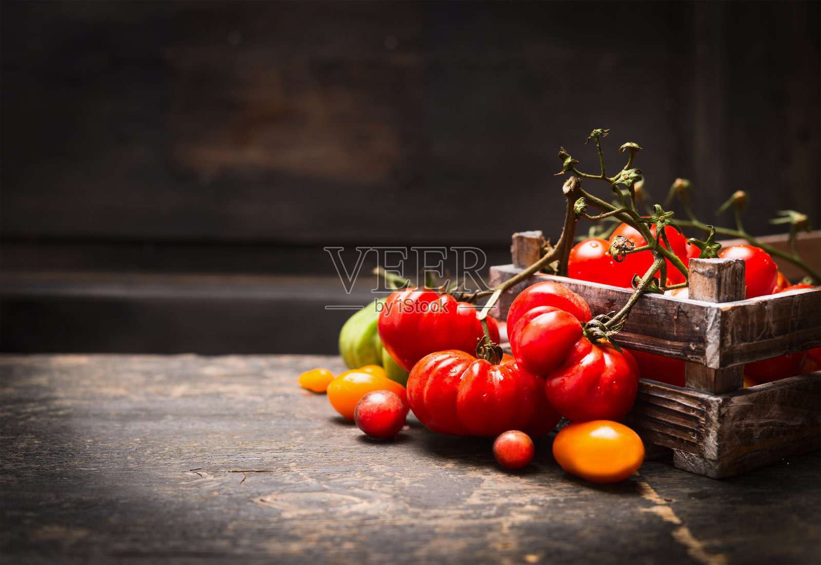 新鲜的有机花园番茄在古董盒上的木制背景。照片摄影图片