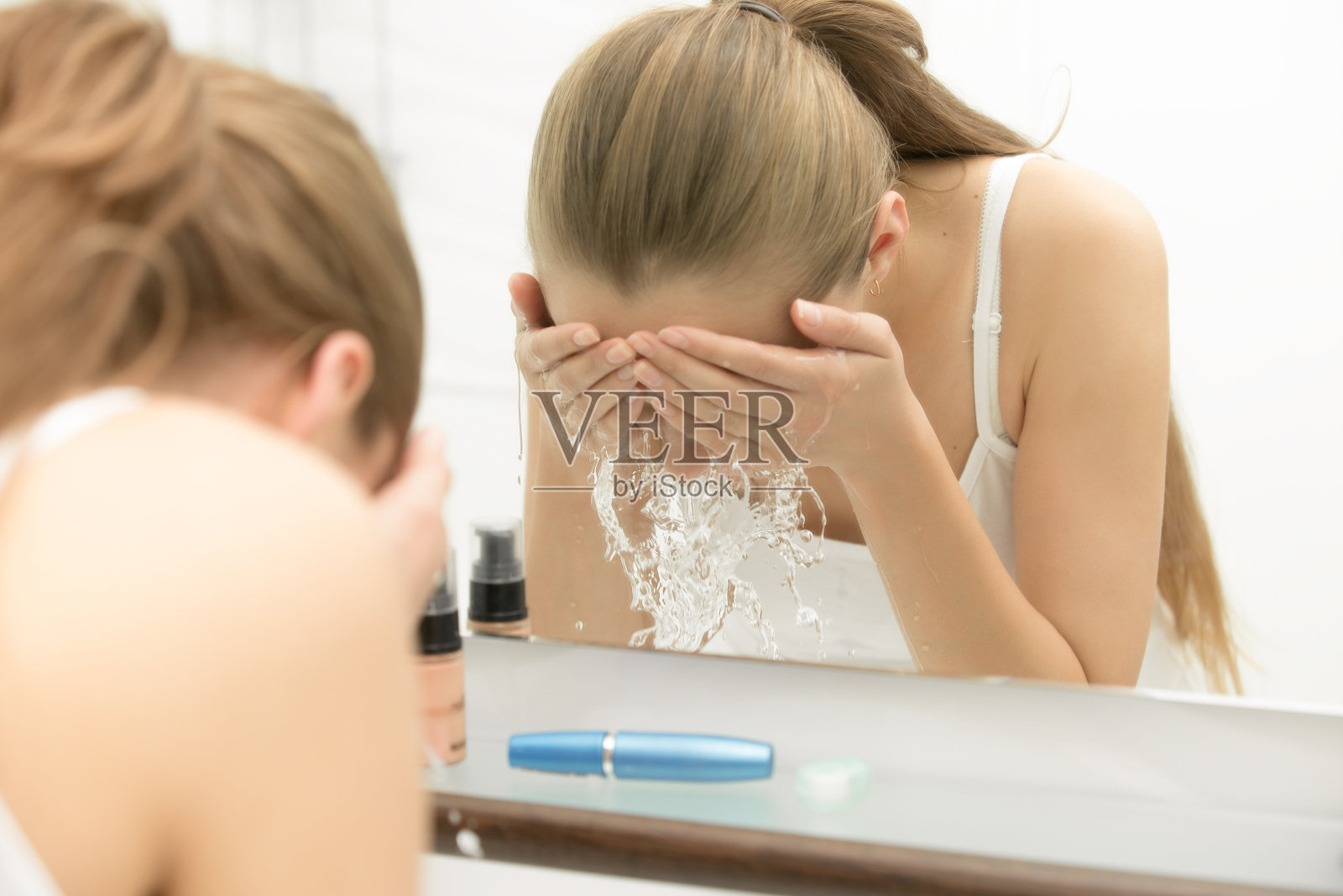 年轻女性用清水洗脸照片摄影图片
