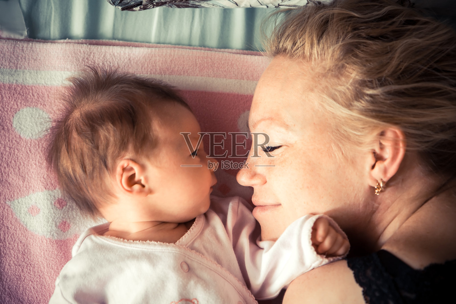 母亲抱着新生婴儿睡觉照片摄影图片