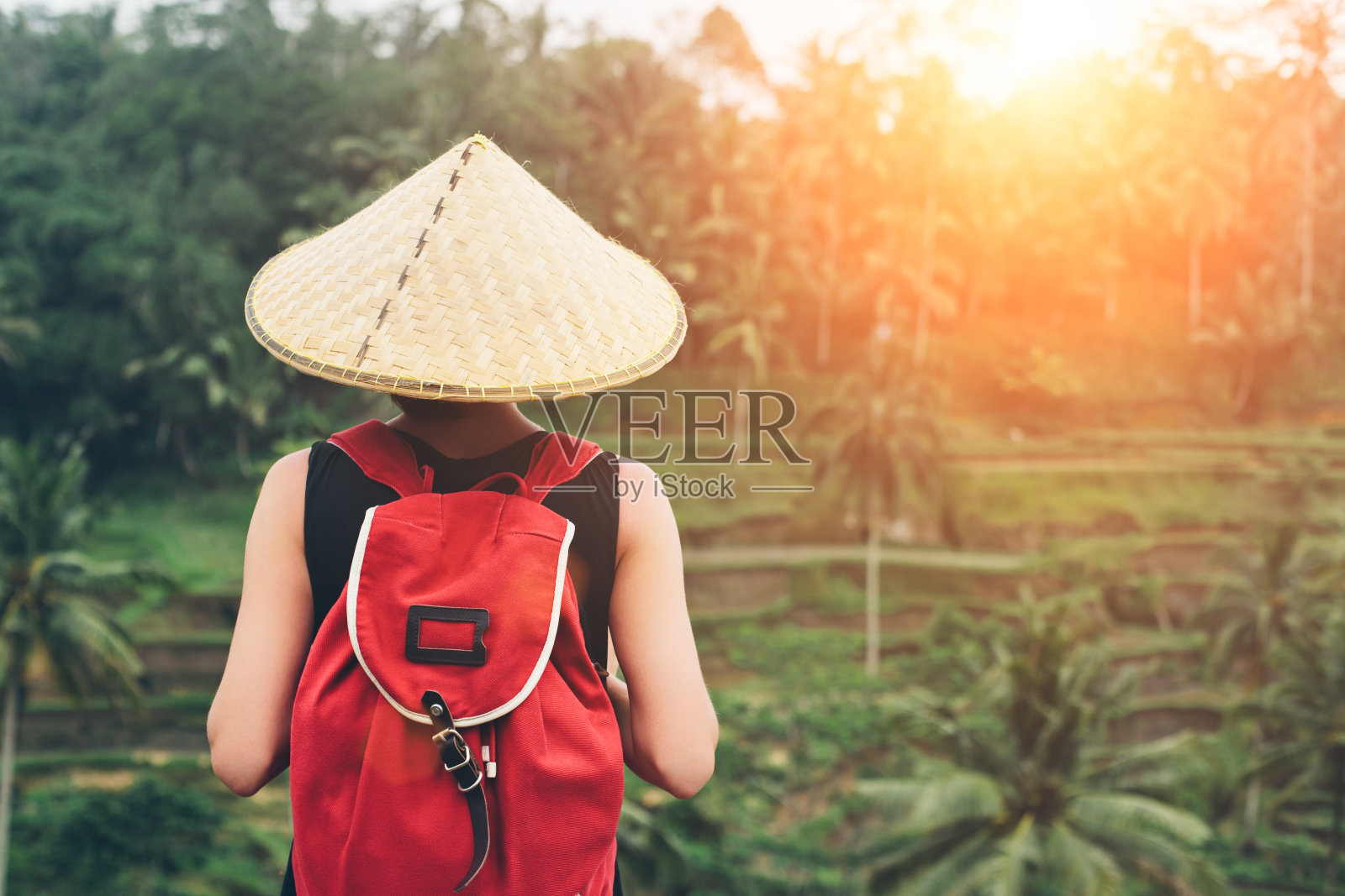 带着传统亚洲帽子和背包的年轻女士照片摄影图片