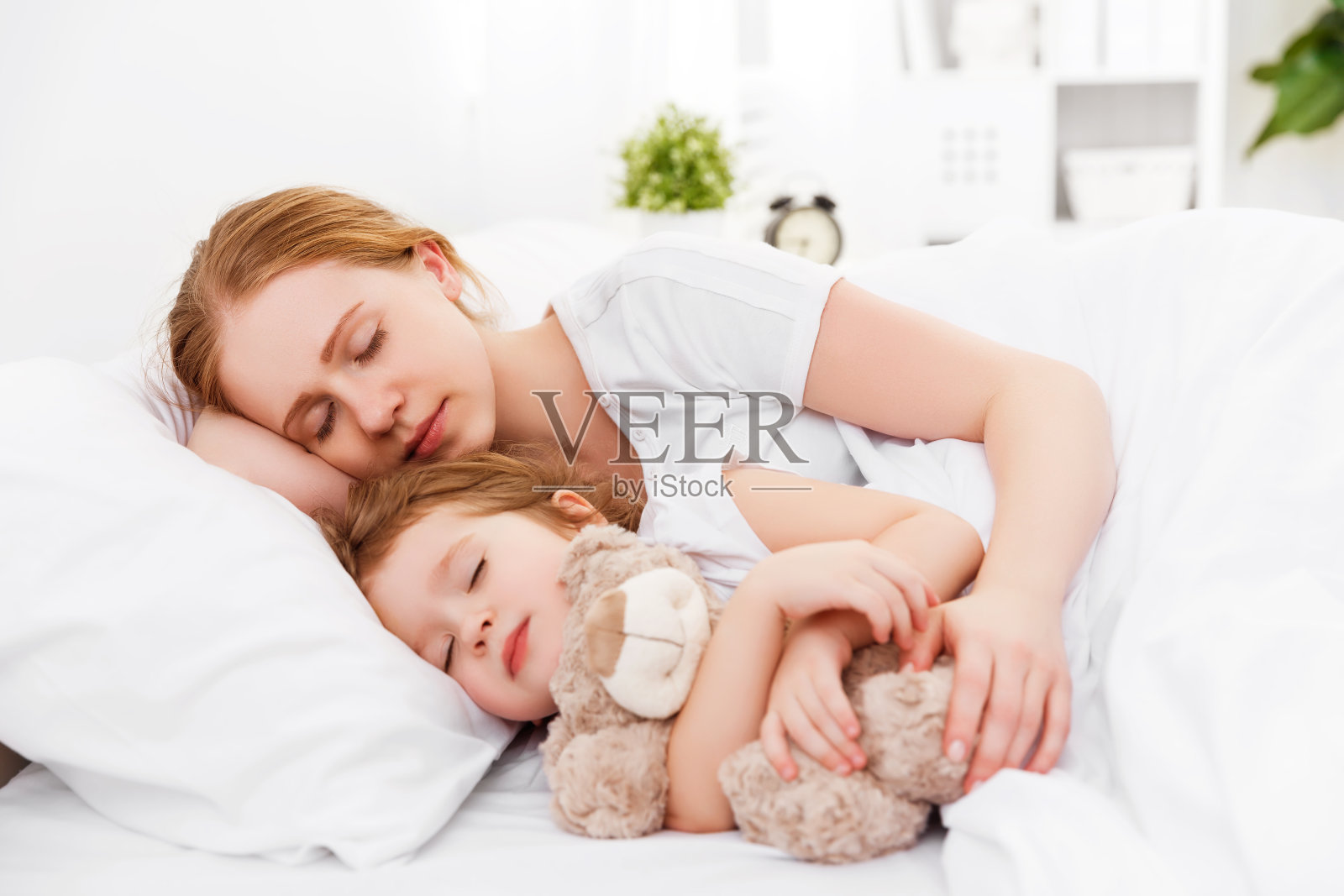幸福的家庭，母亲和孩子睡在床上照片摄影图片