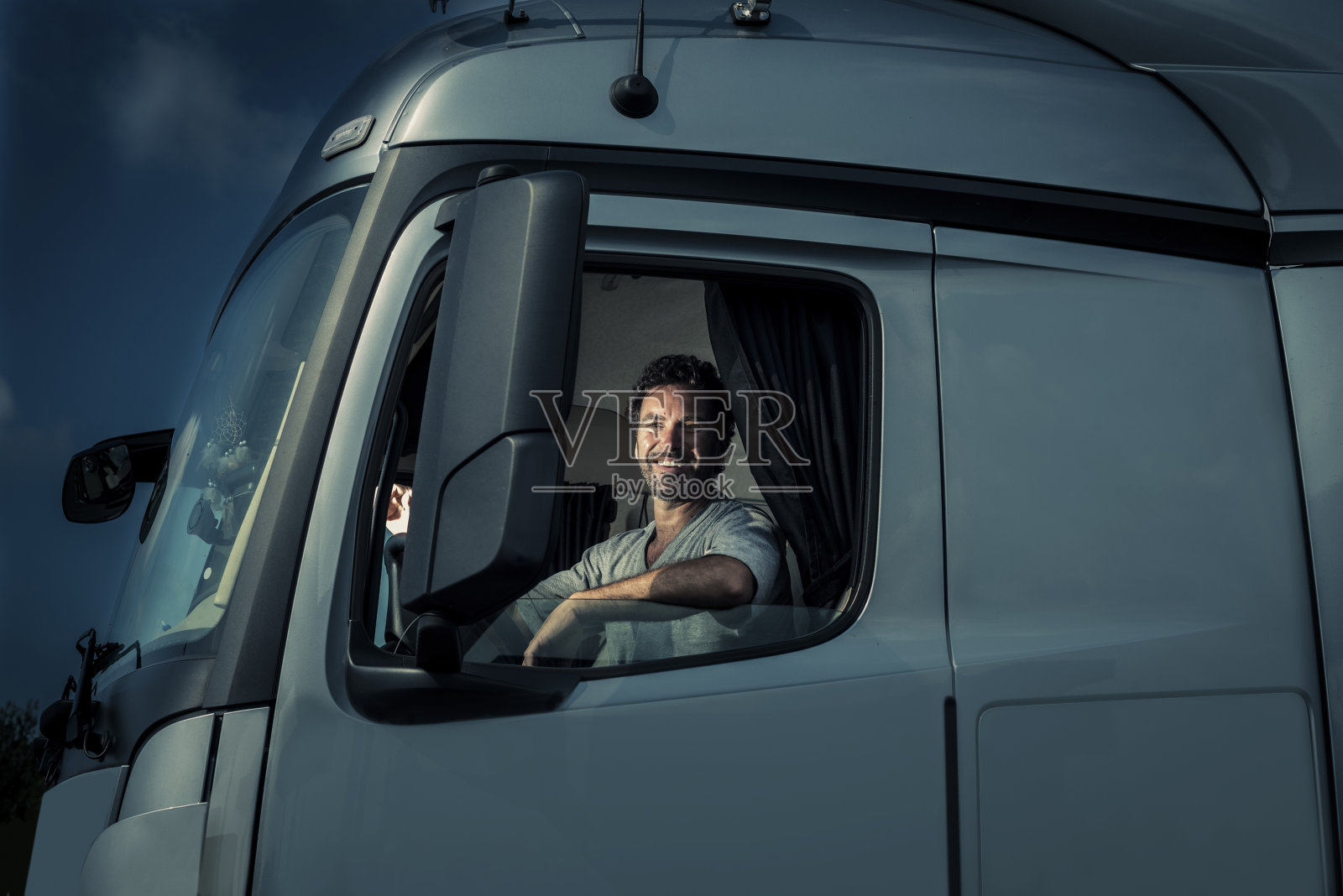 坐在驾驶室里的卡车司机照片摄影图片
