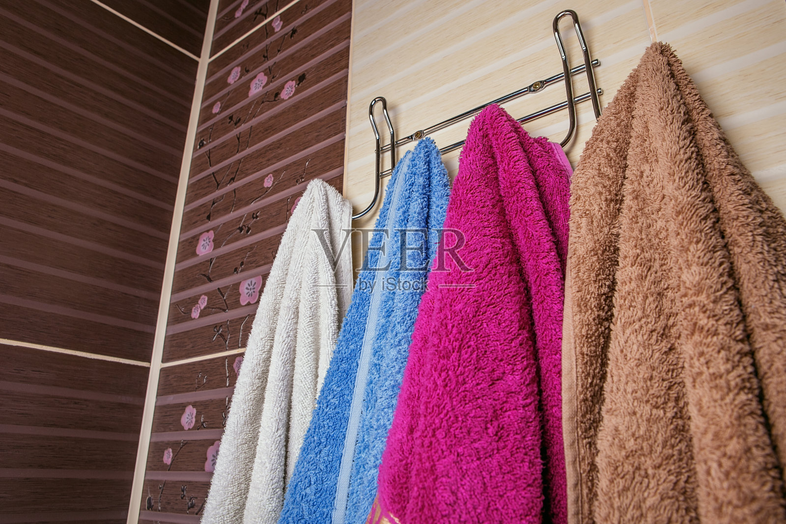 干净的彩色毛巾挂在浴室的架子上。照片摄影图片