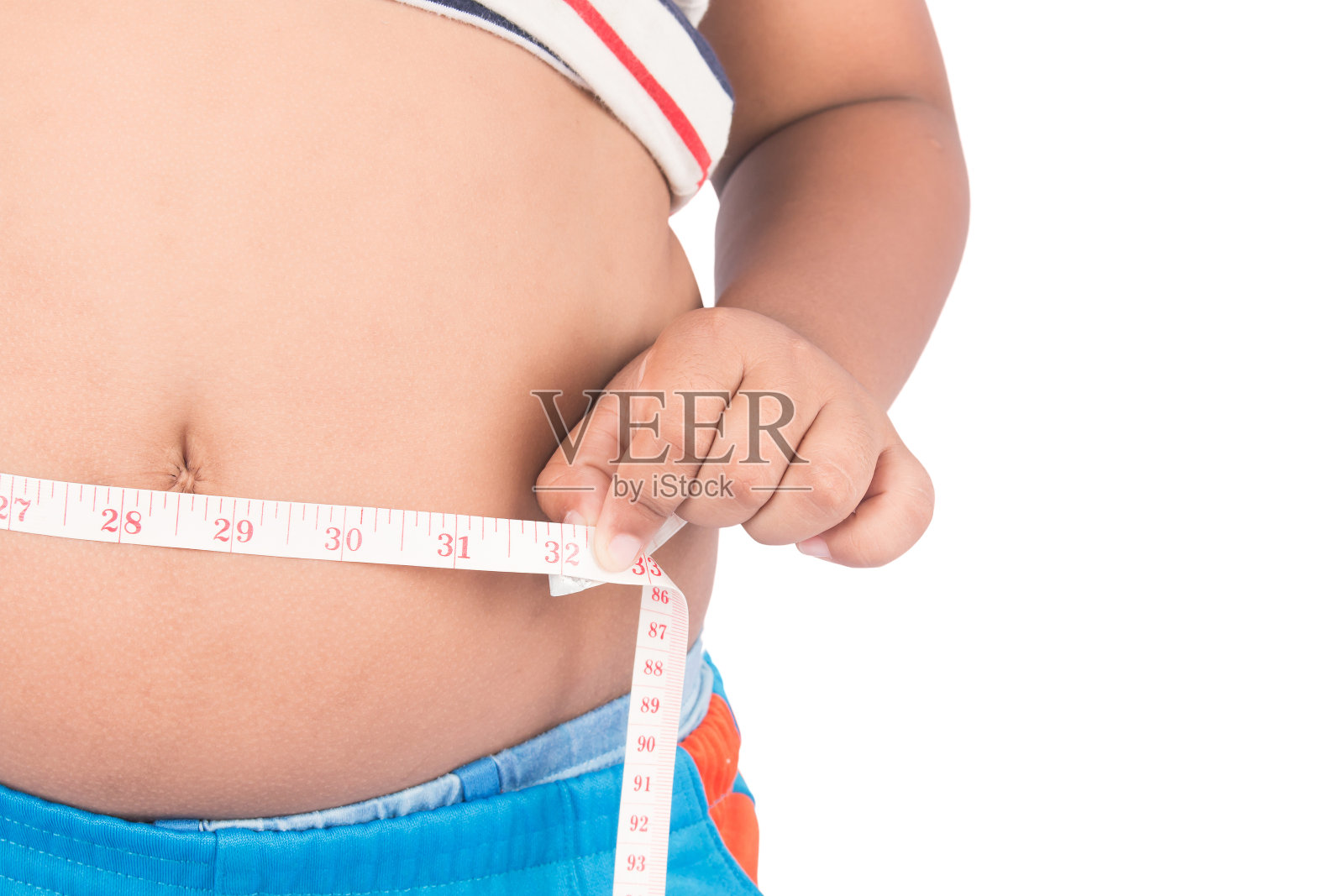用卷尺测量男孩肥胖的身体腹部照片摄影图片