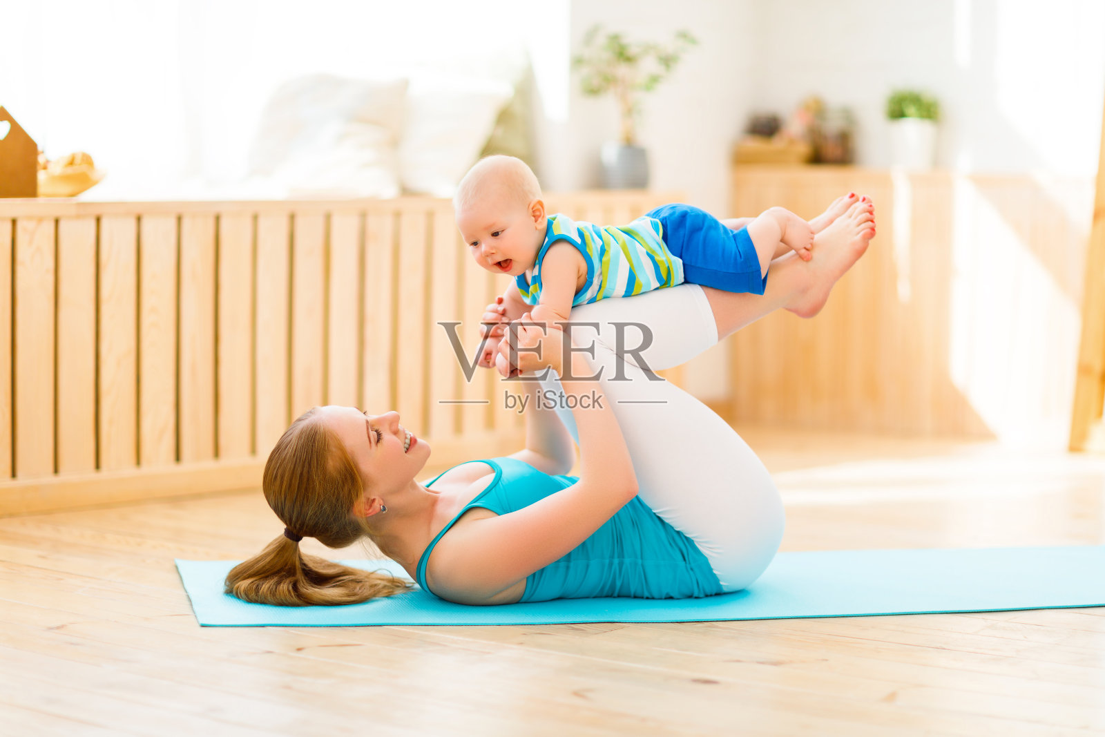 运动妈妈和宝宝一起健身、做瑜伽照片摄影图片