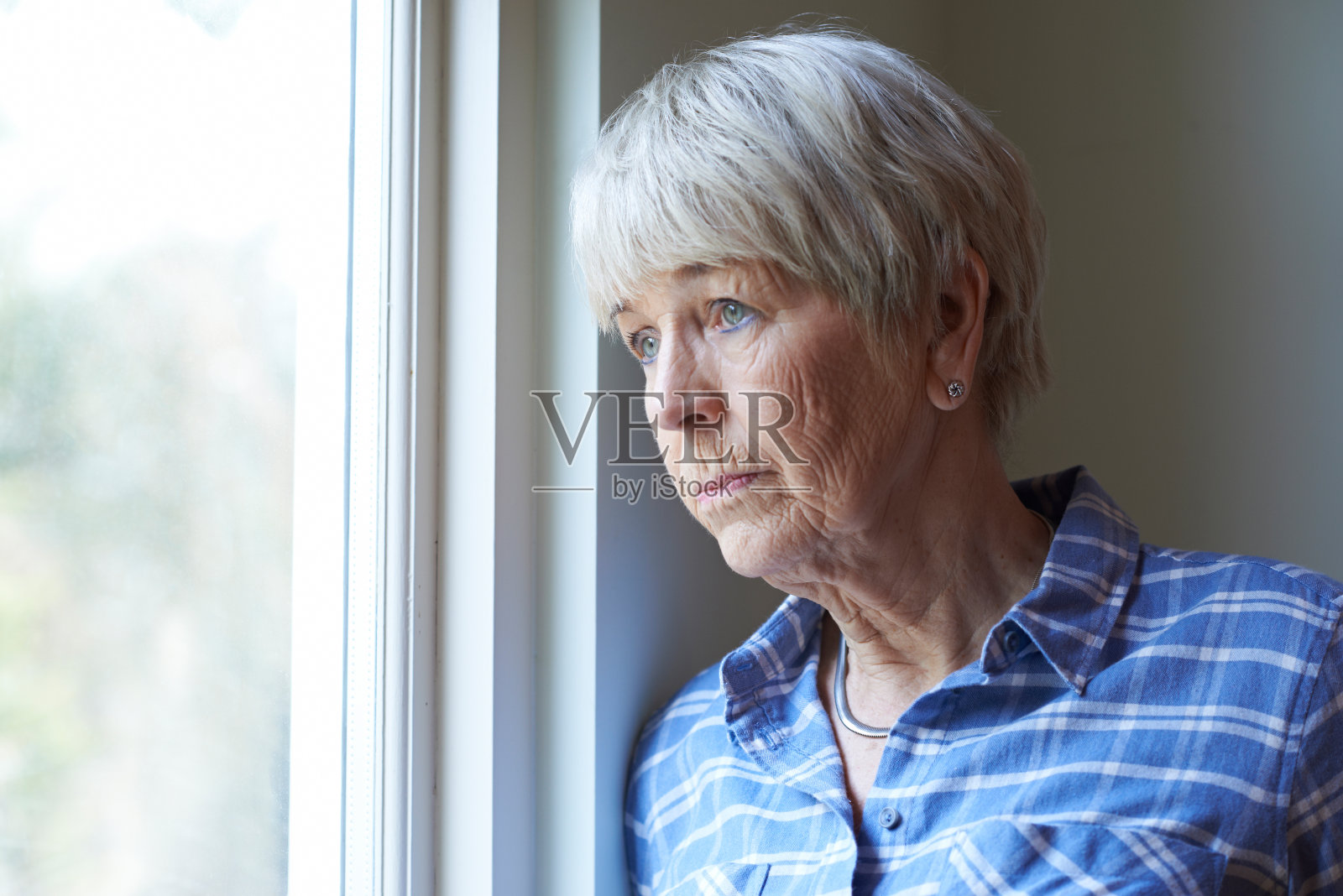 患有抑郁症的老年妇女望着窗外照片摄影图片