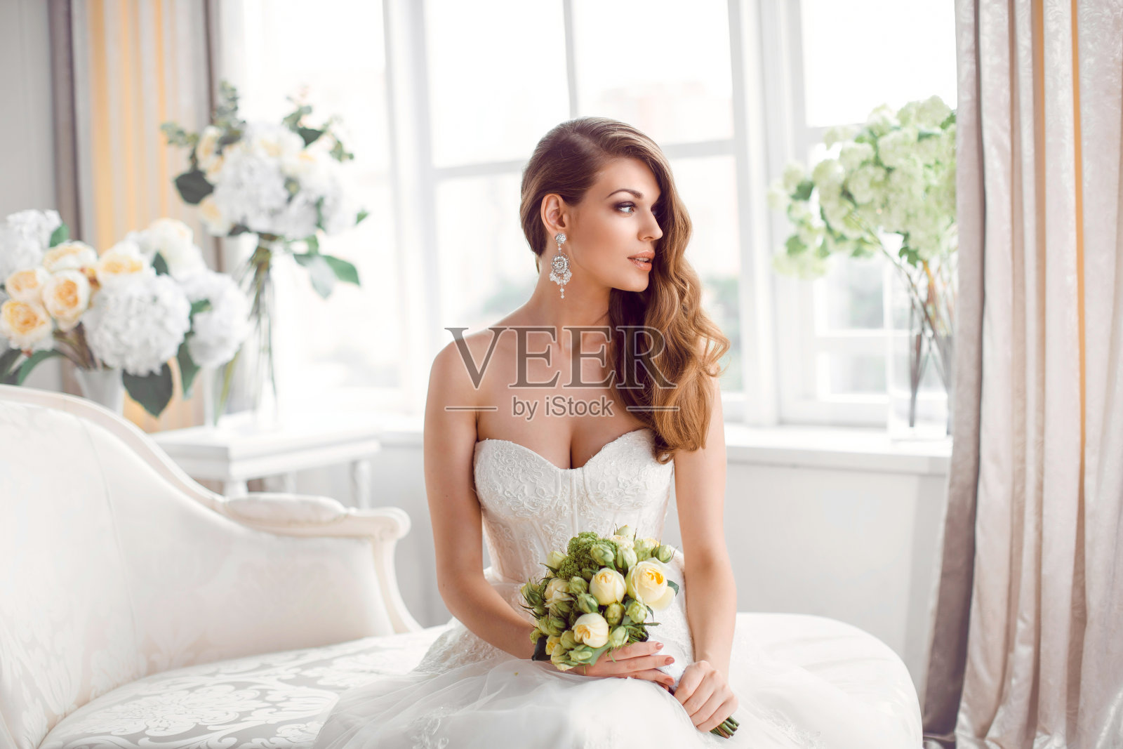 新娘穿着漂亮的礼服坐在室内沙发上休息照片摄影图片