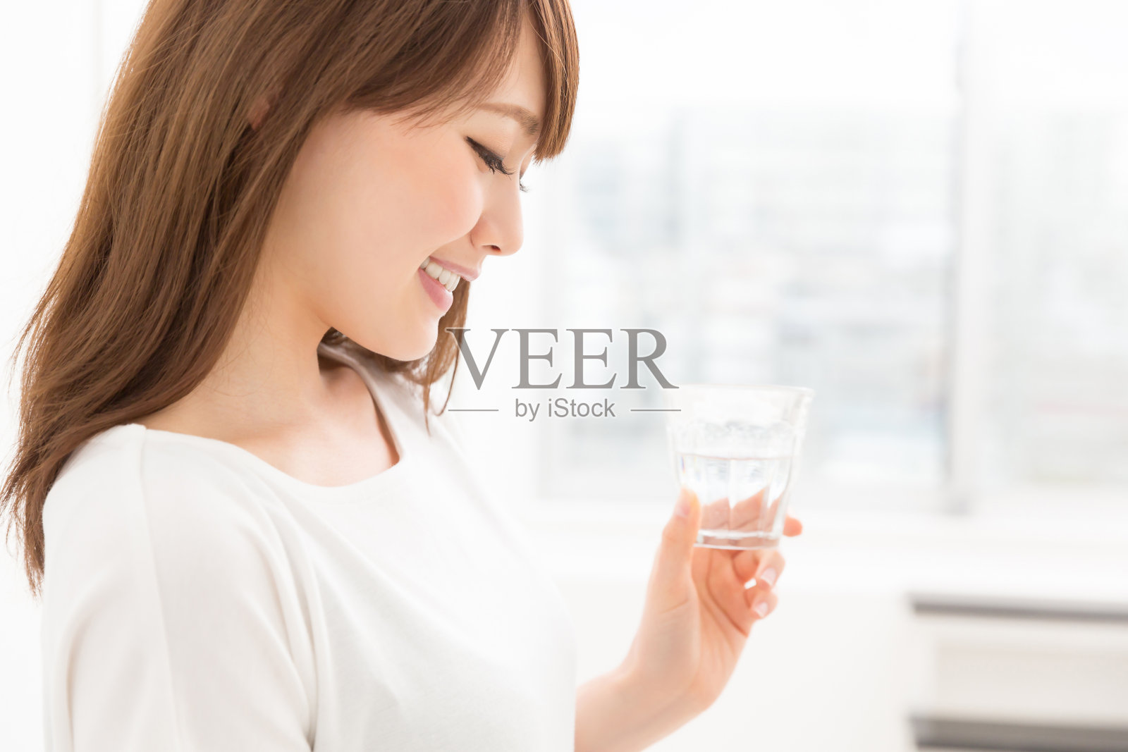 一位日本妇女，手里拿着一杯水照片摄影图片