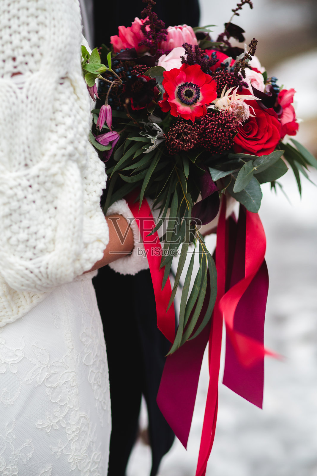 新娘和新郎手拿用胶带粘在一起的婚礼花束，出去了照片摄影图片