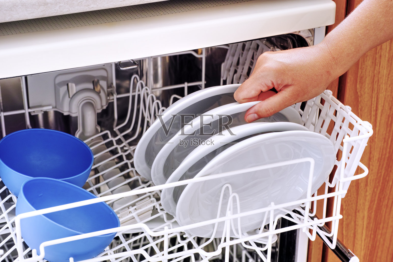 女人用手从洗碗机里拿盘子照片摄影图片