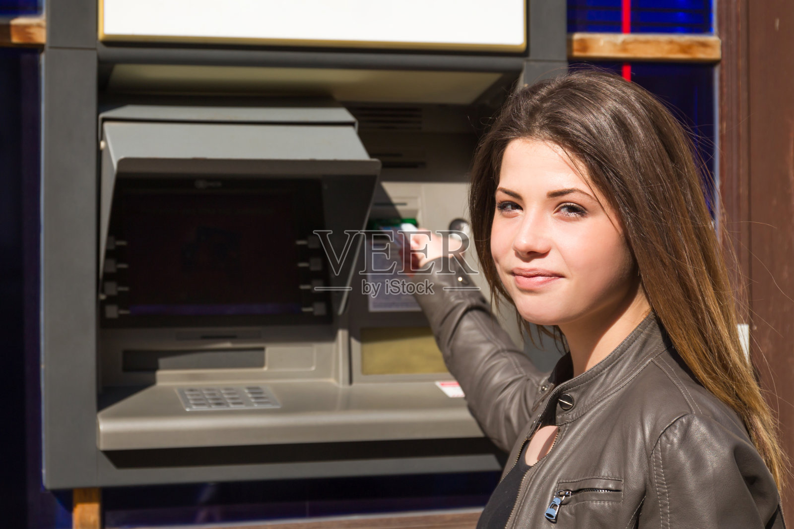 一名女子将信用卡插入自动取款机照片摄影图片
